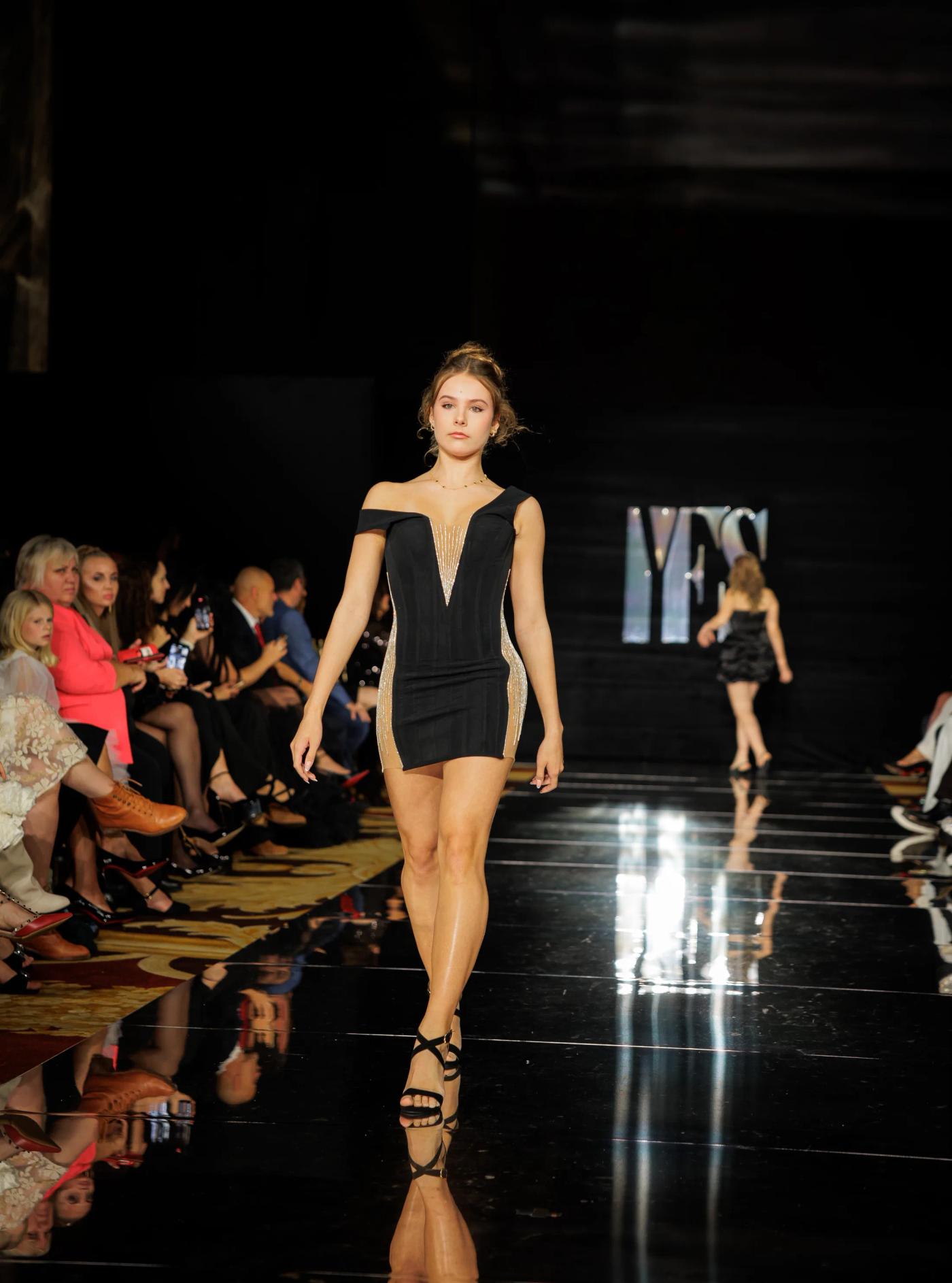 A model in a black cut-out dress on the YFS runway