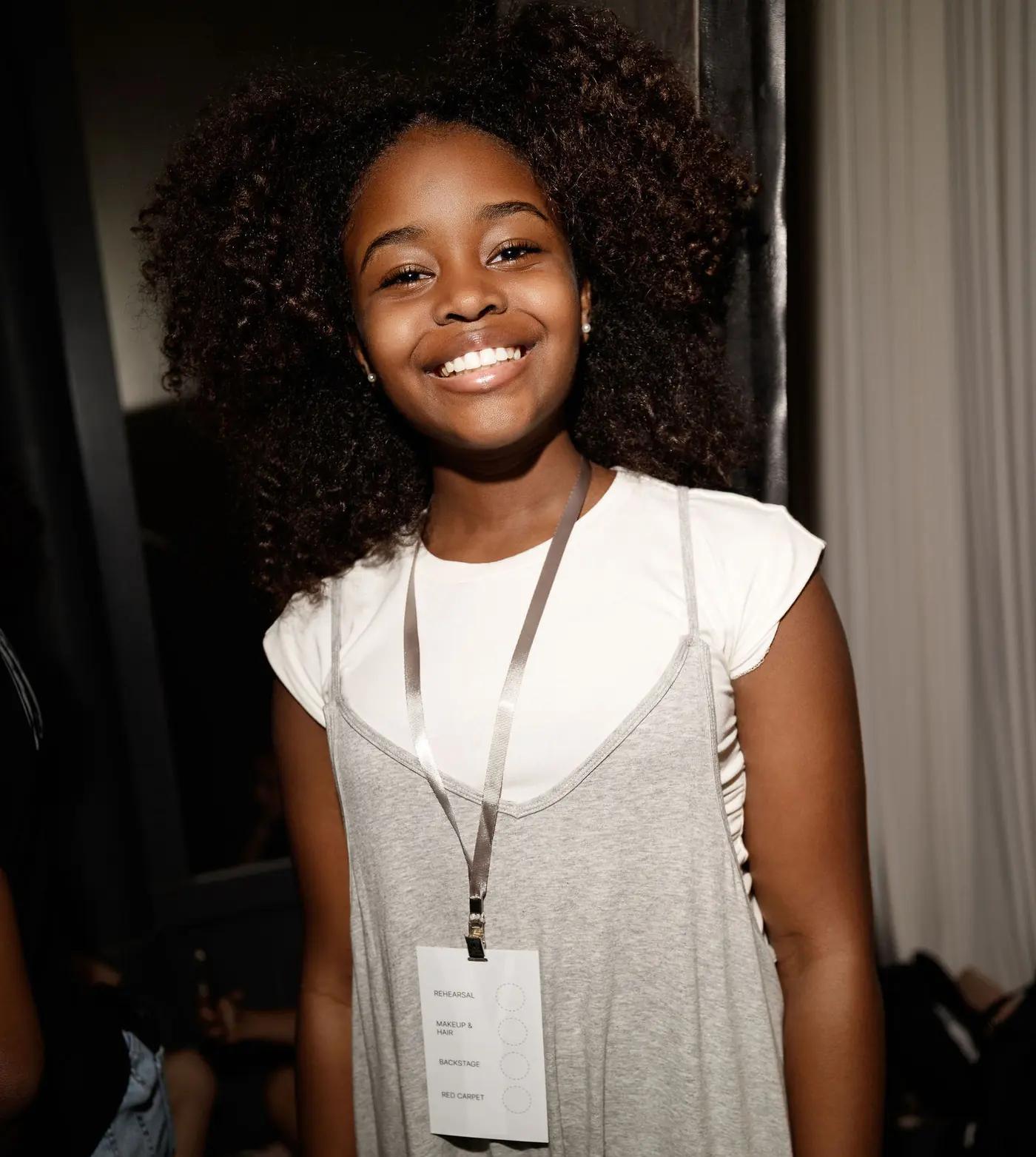 Smiling participant backstage wearing a YFS lanyard