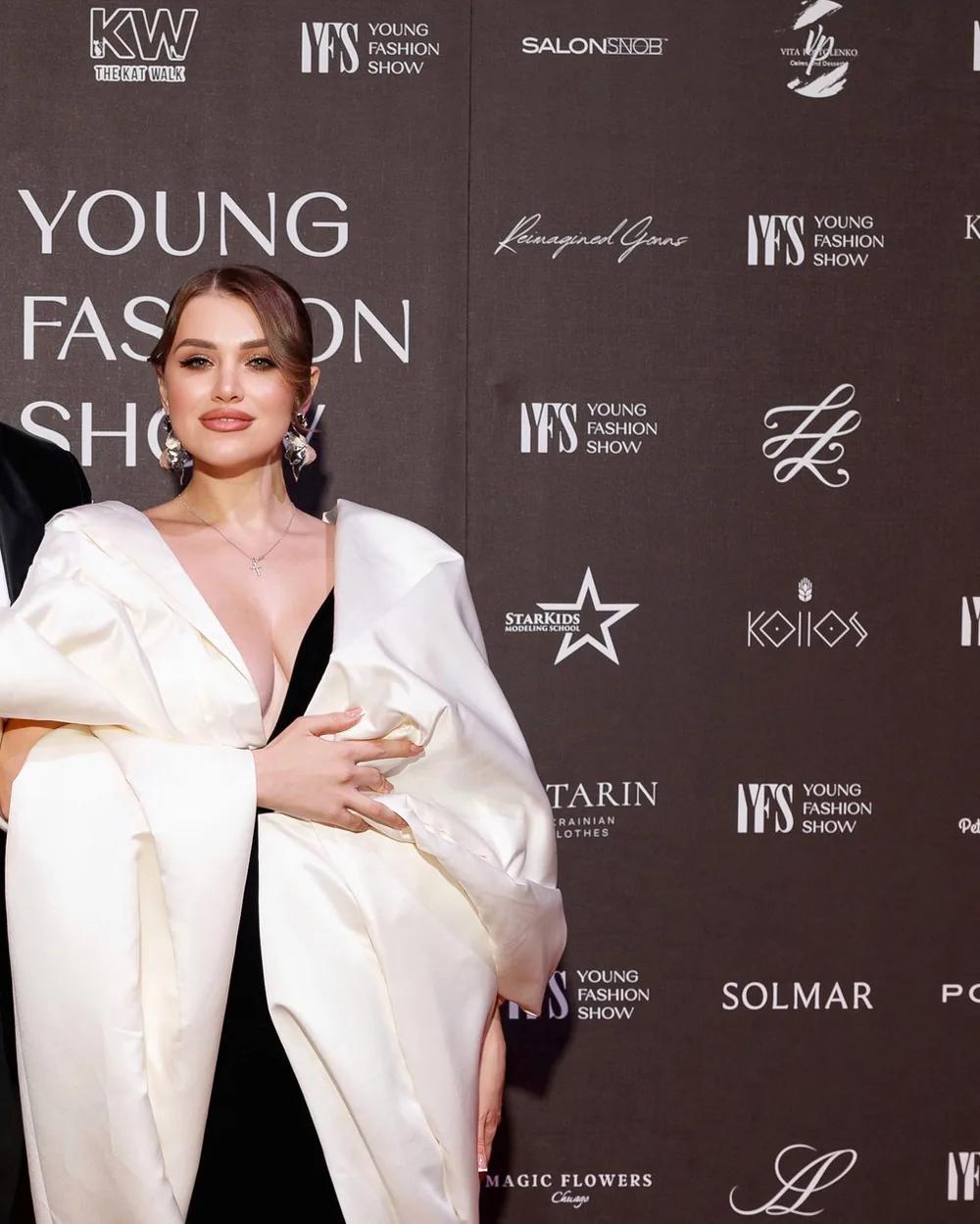 A guest in a sculptural white coat on the YFS red carpet
