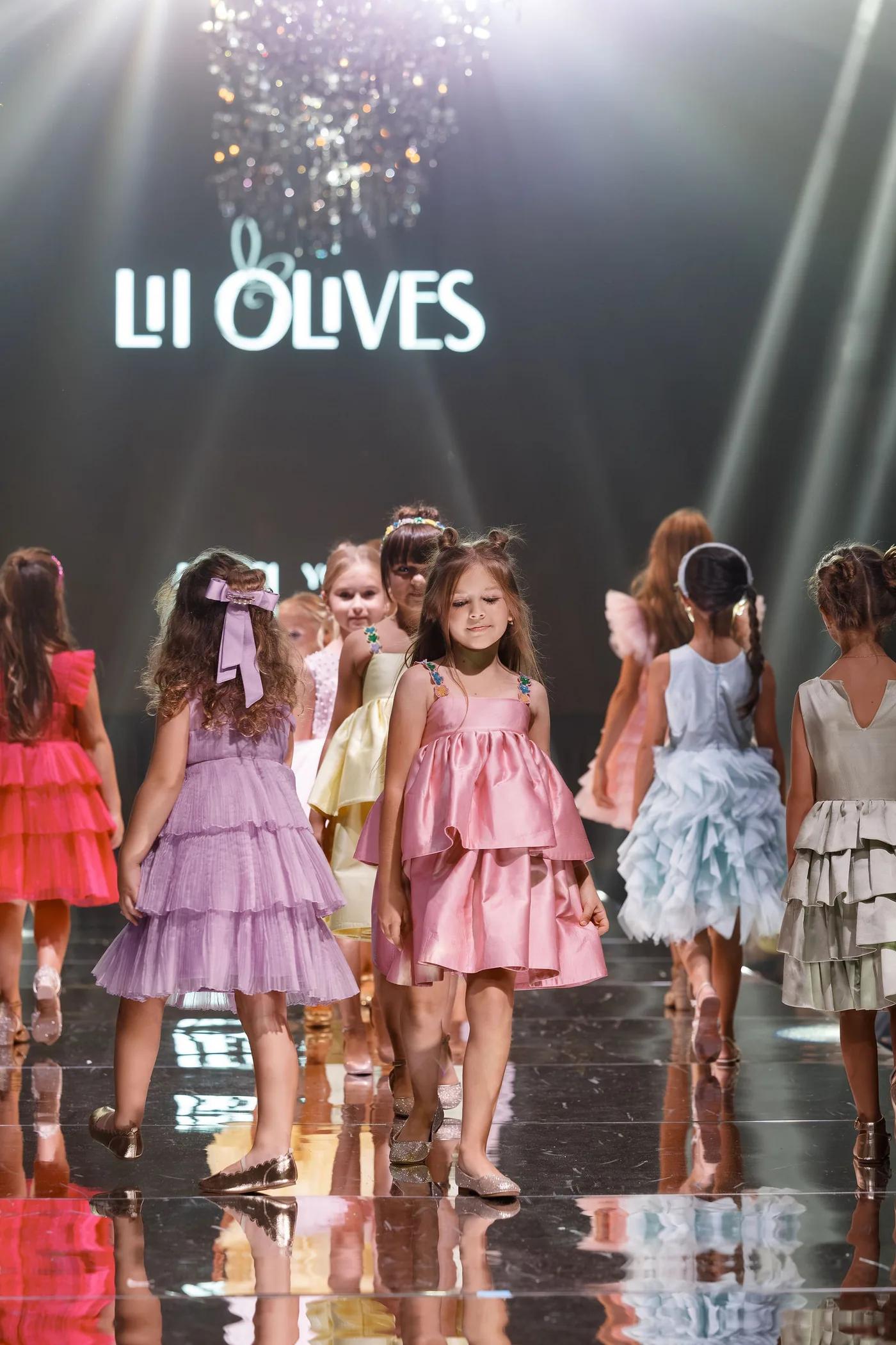 The Lil Olives group finale on the YFS runway, the brand on the screen behind
