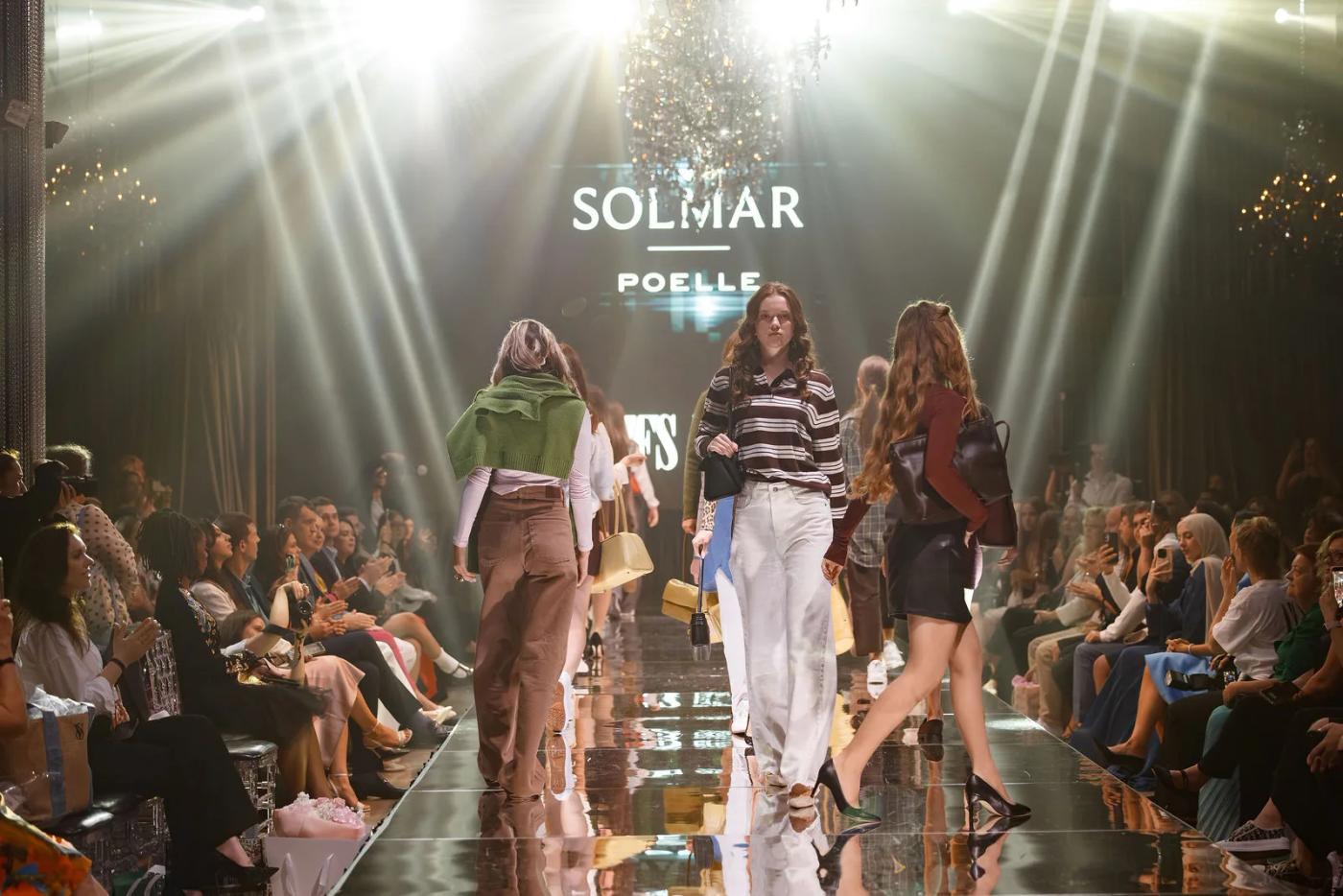 Teen models in Solmar on the YFS runway, the brand on the screen behind