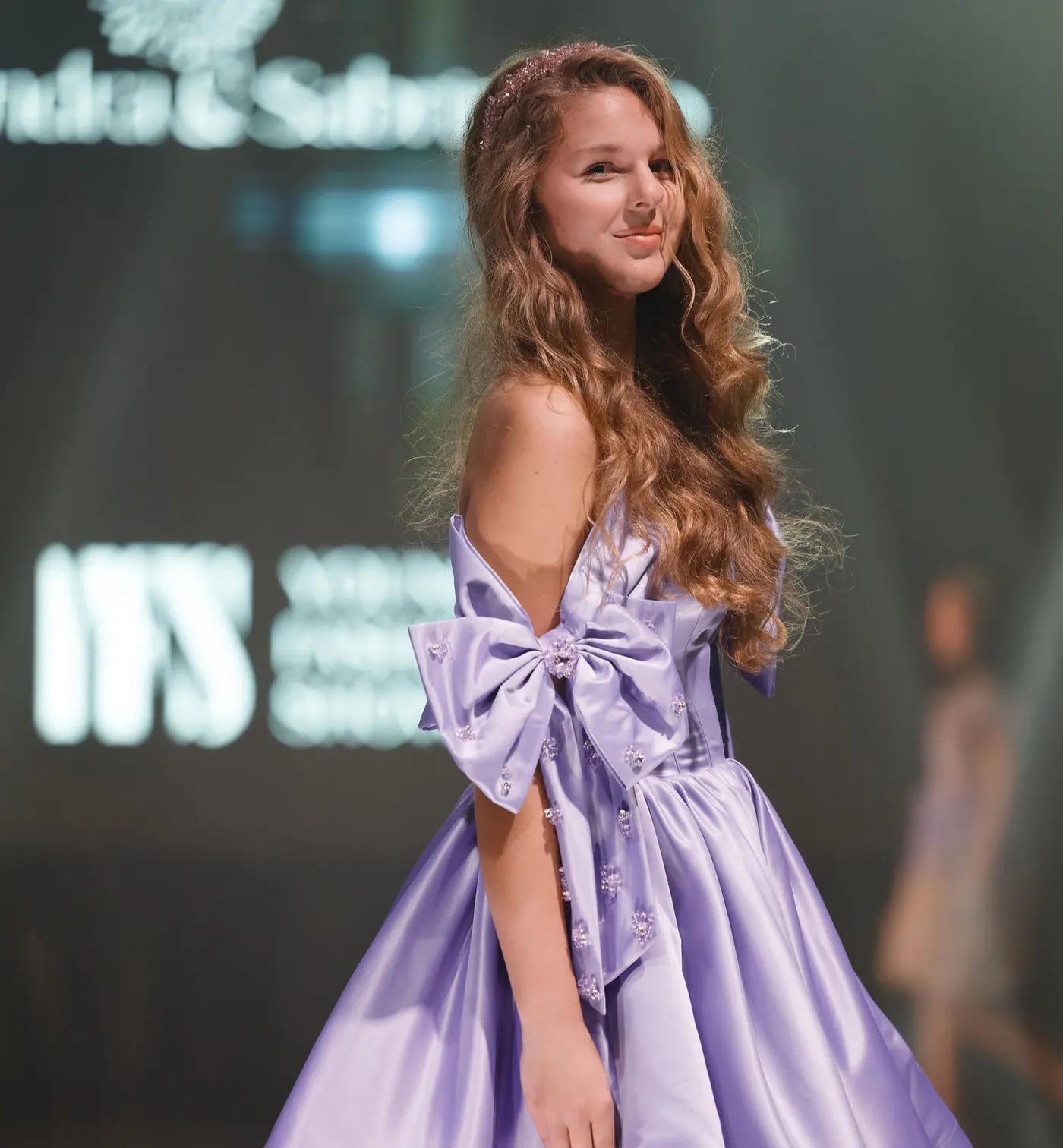 Girl in a lilac bow gown on the runway
