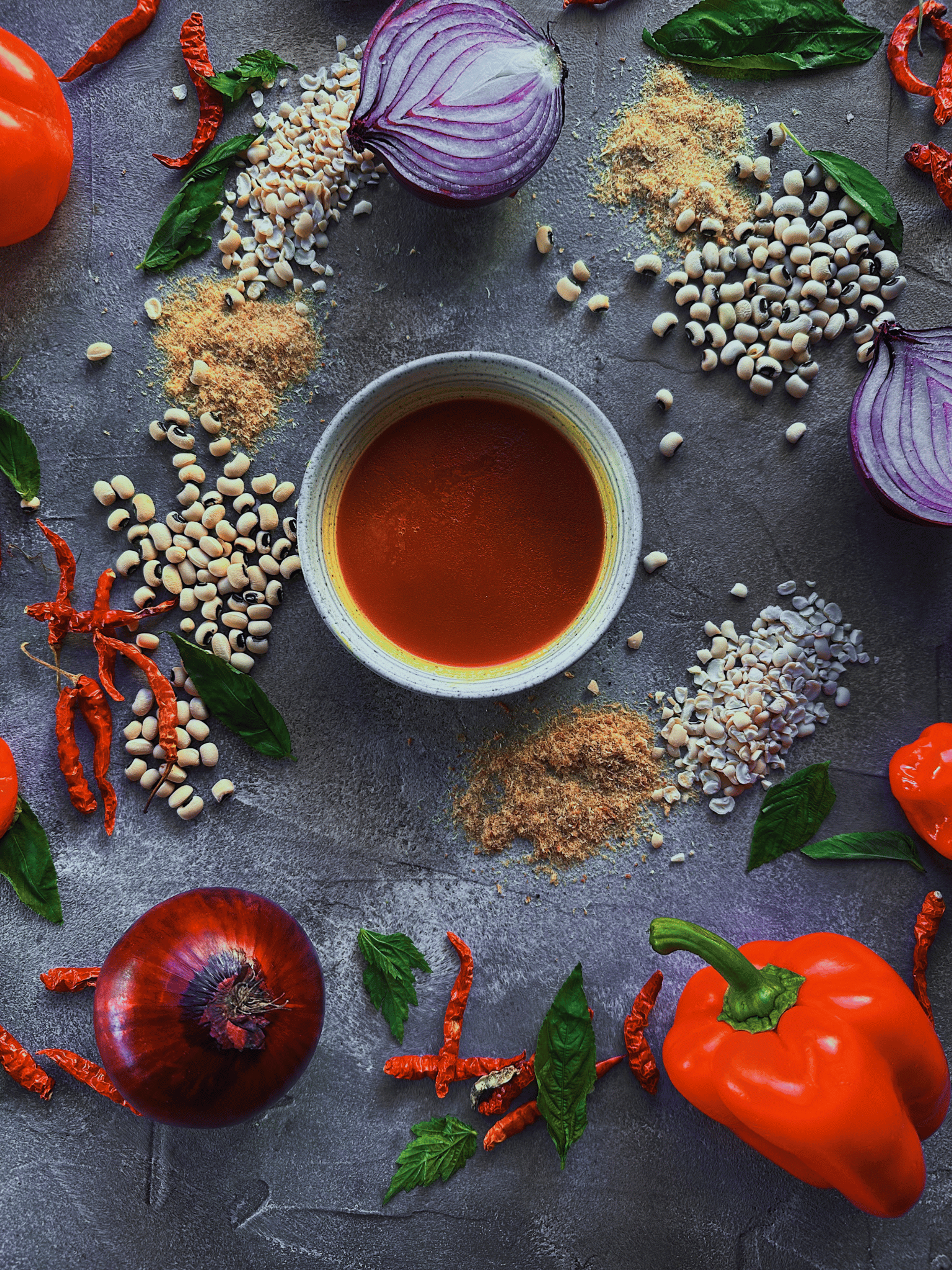 West African ingredients arranged around a bowl of red pepper sauce