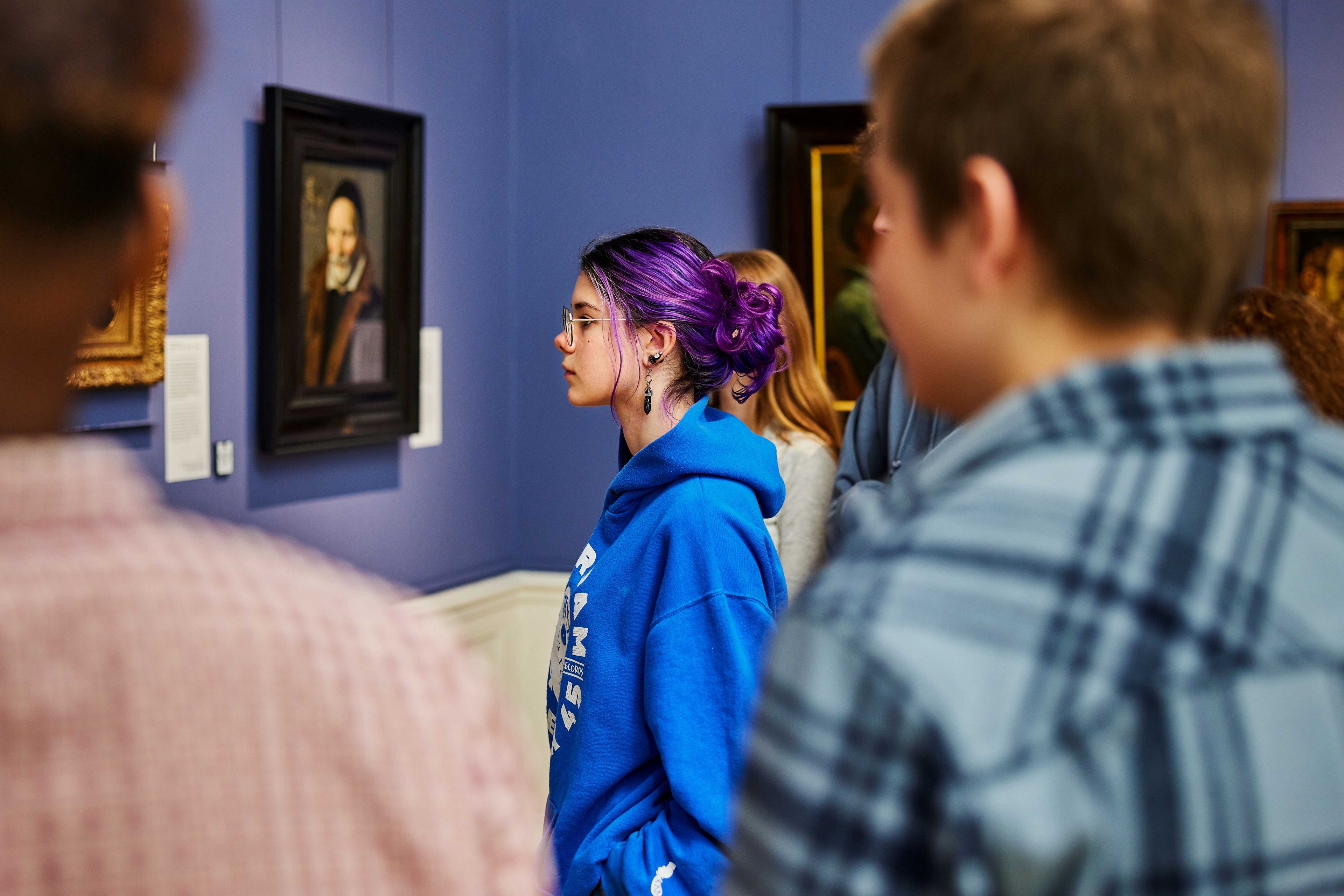 Secondary school pupil and her classmates looking at a painting by Frans Hals. 