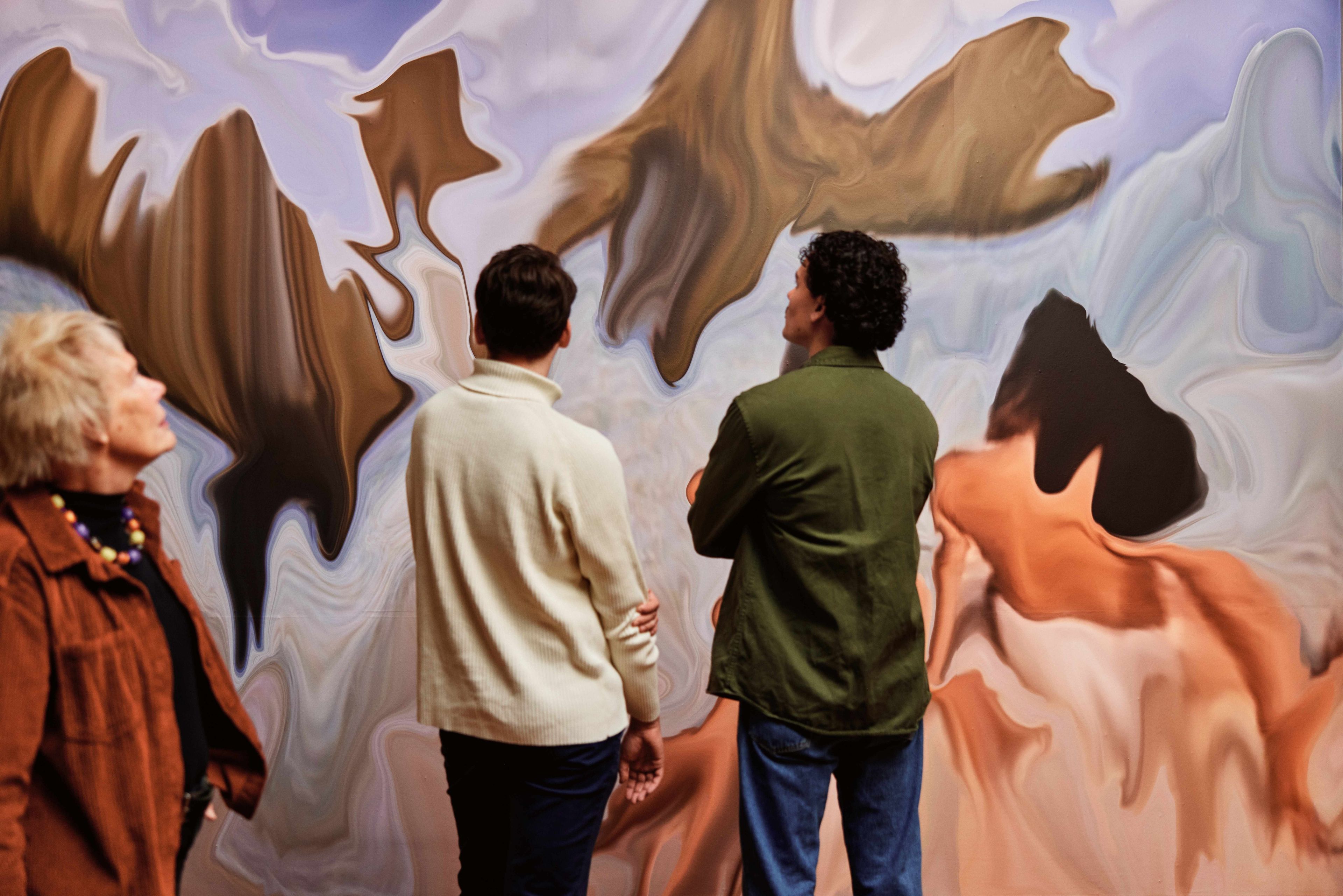 Two visitors looking at ‘Jennifer in Paradise’ by Constant Dullaart.