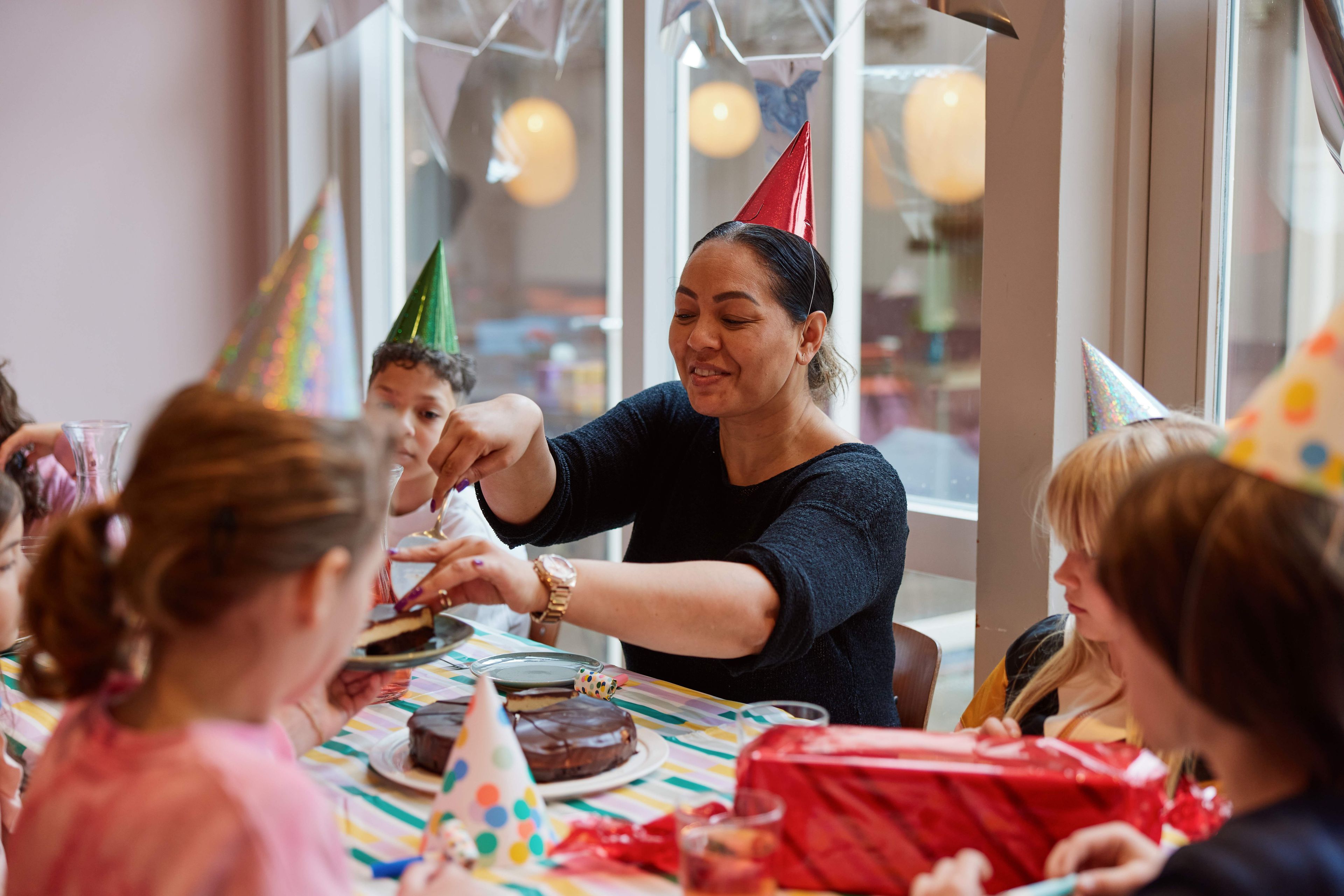 Kinderen vieren een verjaardag in het Frans Hals Museum en moeder snijdt de taart aan.