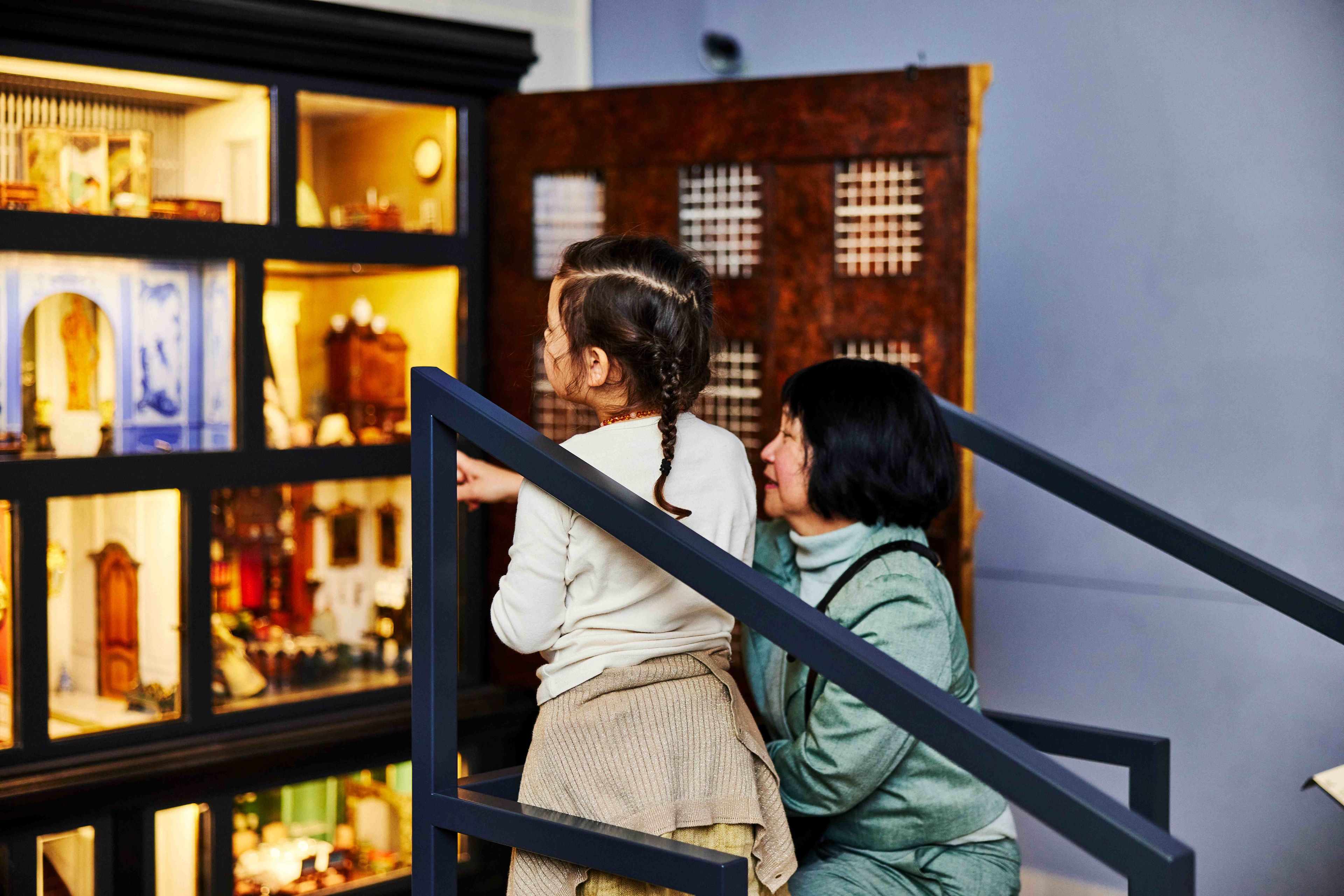Moeder en kind bekijken samen het Poppenhuis in het Frans Hals Museum.