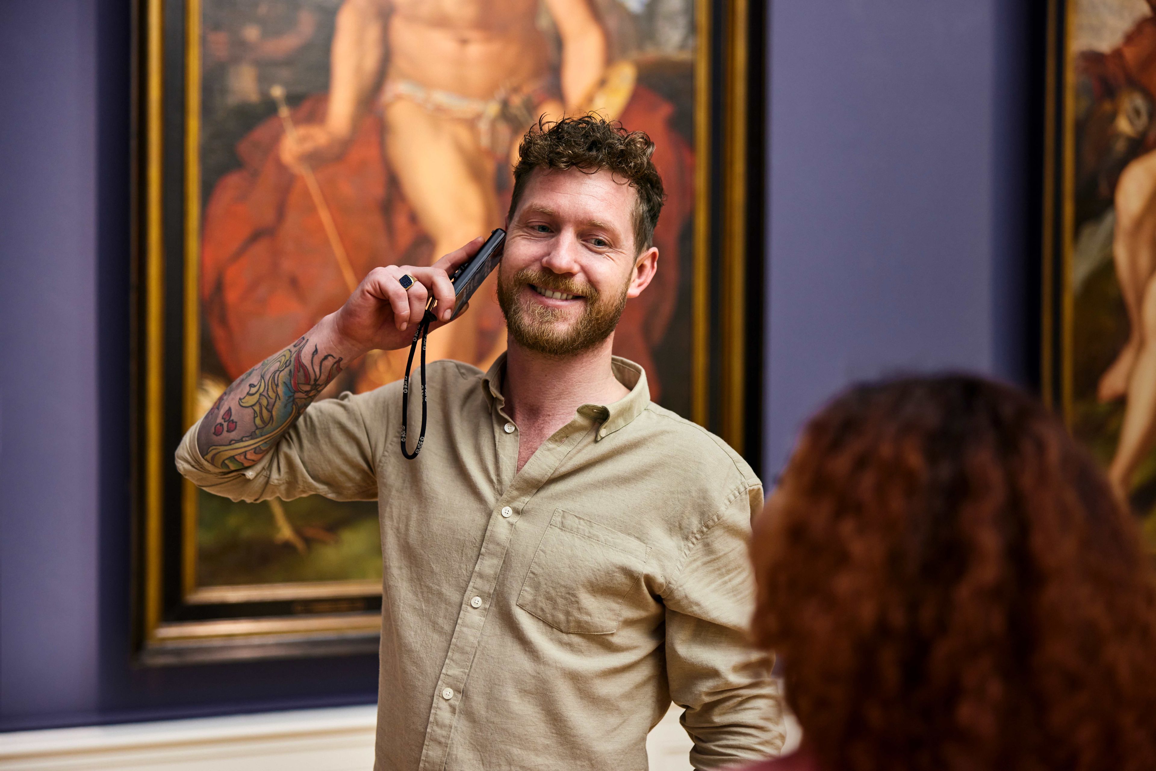 Mannelijke bezoeker luistert via de gratis audiotour naar het verhaal over het kunstwerk.
