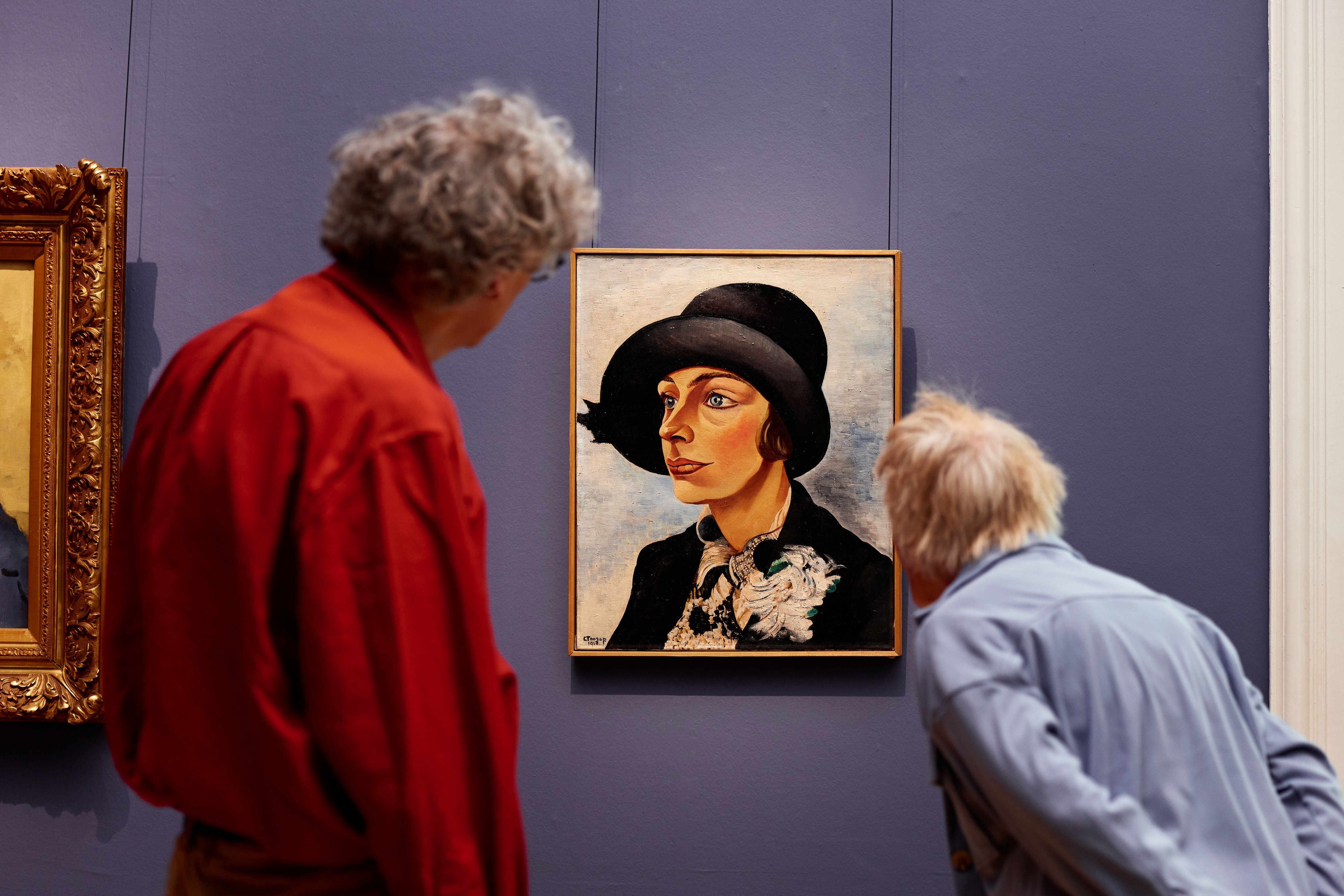 Twee bezoekers kijken naar het kunstwerk 'Dame met zwarte hoed' van Charley Toorop in het Frans Hals Museum.