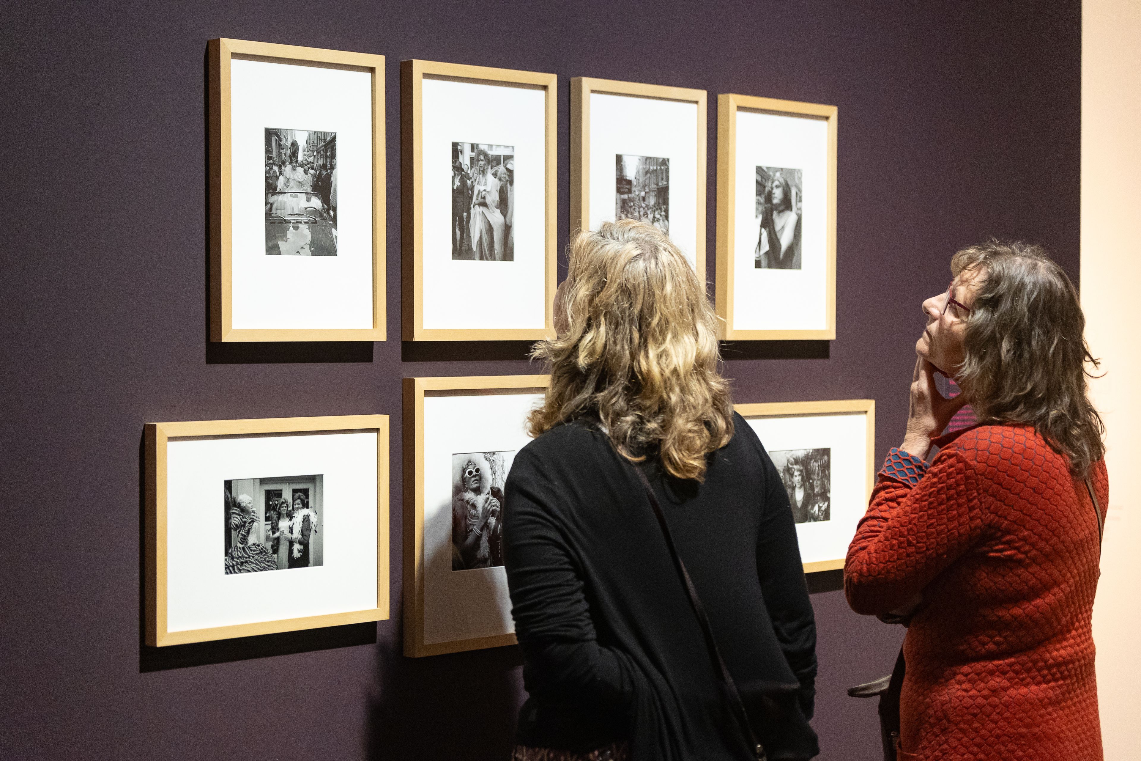 Bezoekers bekijken de foto's van ballroom tijdens hun bezoek aan tentoonstelling The Art of Drag in het Frans Hals Museum locatie HAL.
