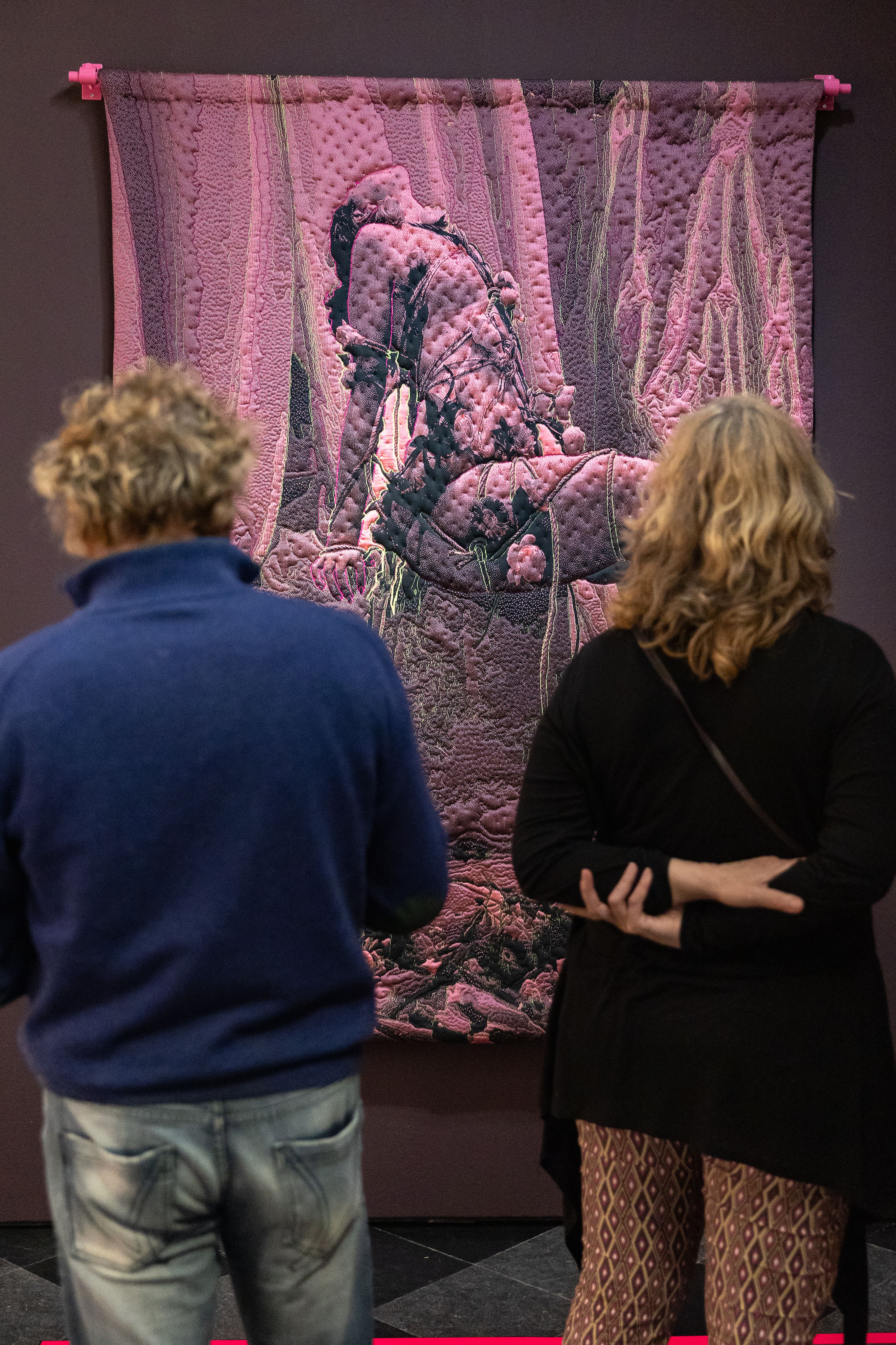 Bezoekers bekijken het kunstwerk aan de muur van Yamuna Forzani tijdens de tentoonstelling The Art of Drag in HAL.
