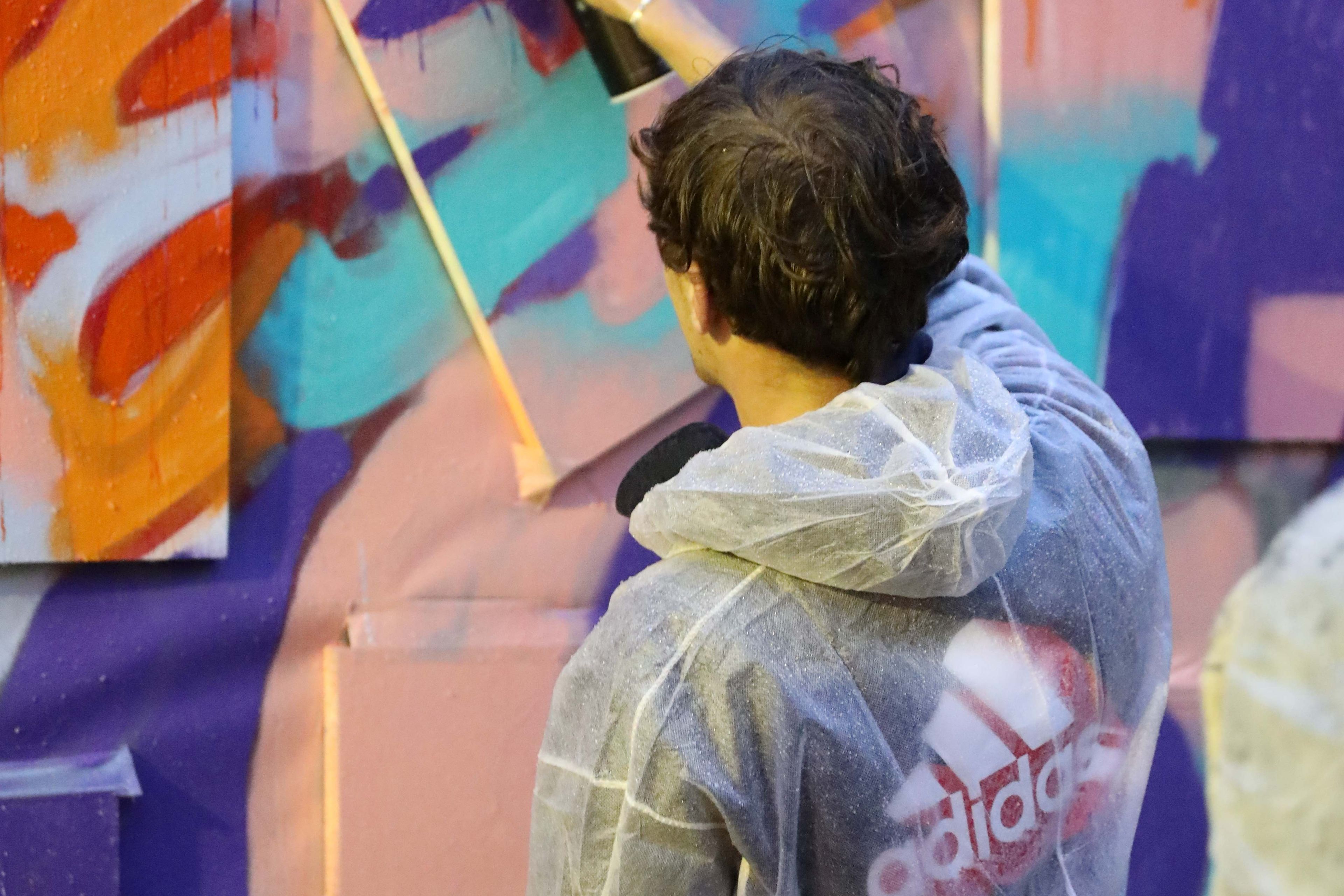 Jongen spuit graffiti tijdens de workshop bij tentoonstelling ON THE SPOT.