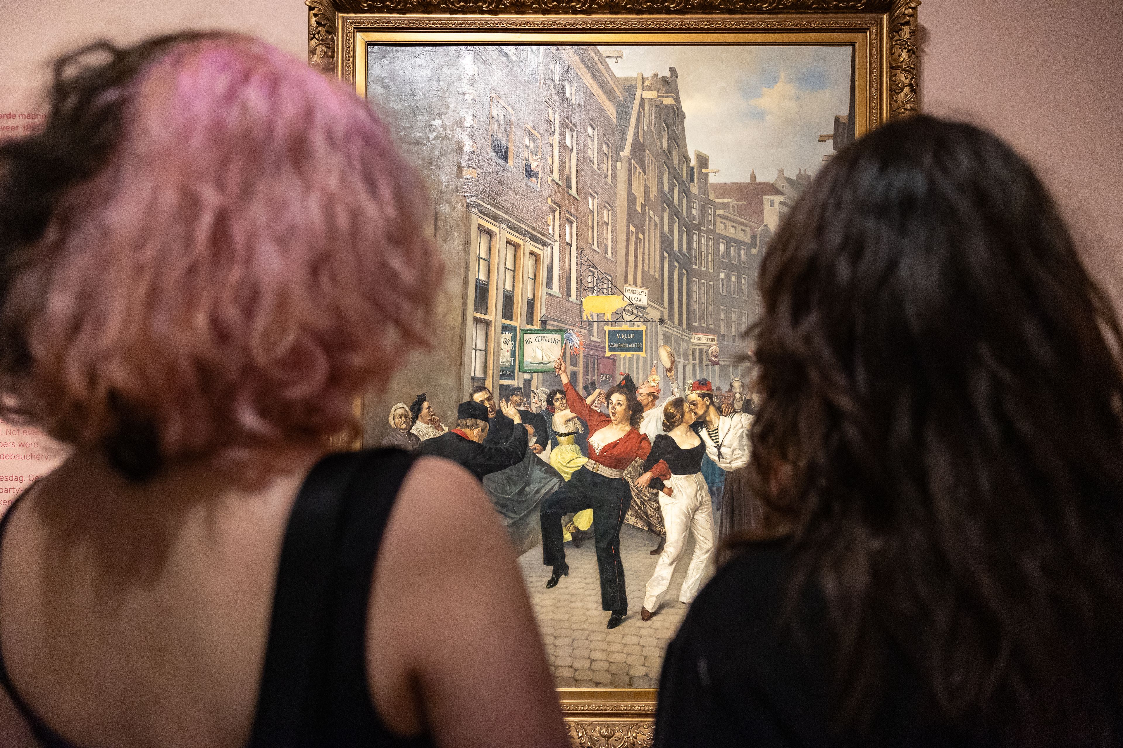 Bezoekers bekijken het kunstwerk van Johan Coenraad Braakensiek tijdens hun bezoek aan tentoonstelling The Art of Drag in het Frans Hals Museum locatie HAL.