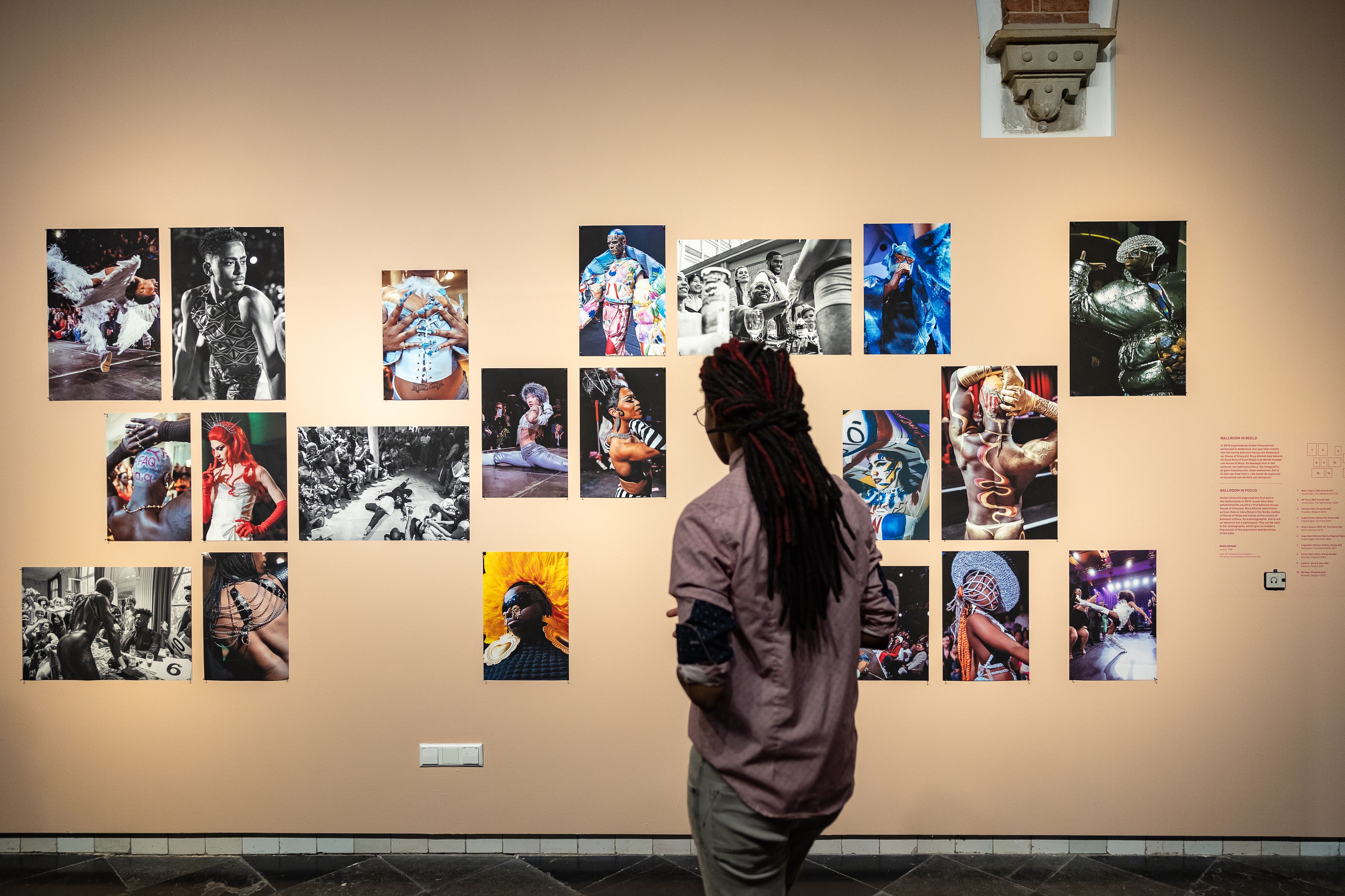 Bezoeker bekijkt de foto's van ballroom tijdens haar bezoek aan tentoonstelling The Art of Drag in het Frans Hals Museum locatie HAL.