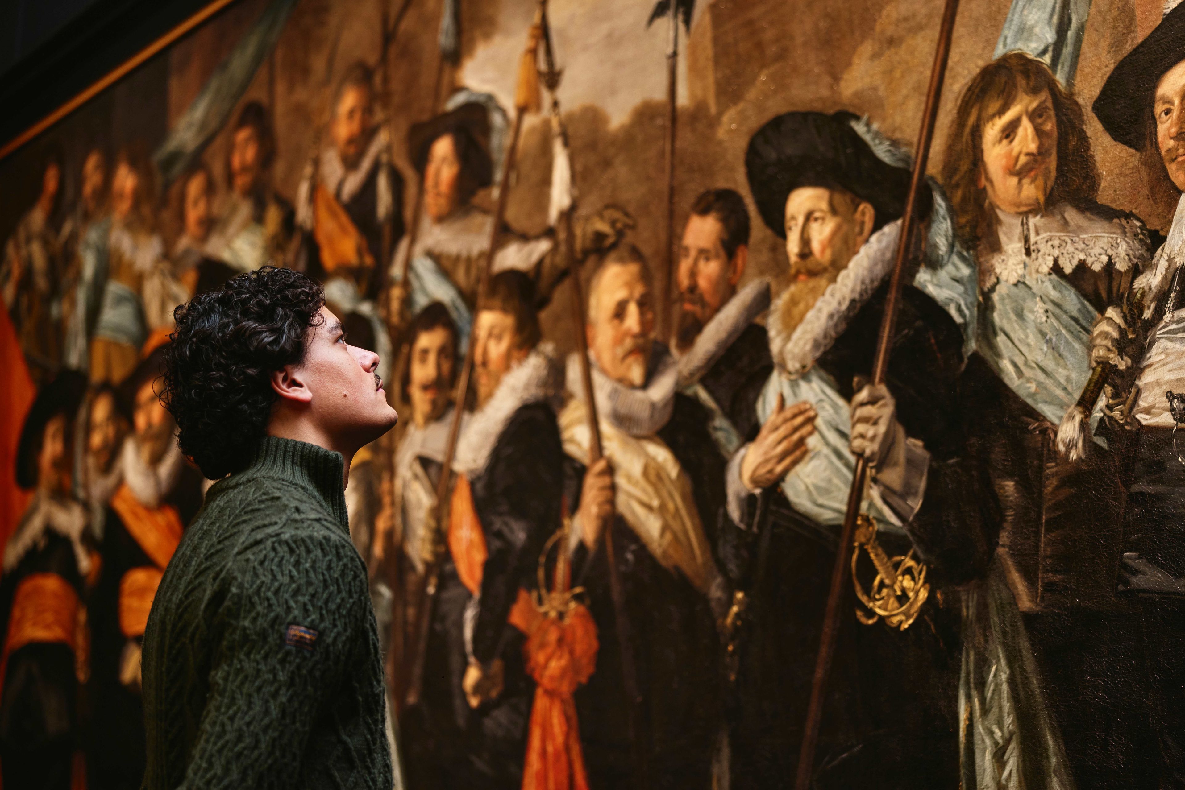 Visitor looking at a group portrait of civic guards by Frans Hals at the Frans Hals Museum 