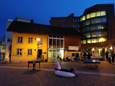 belebter Märplatz mit Pingpongtisch und Jöggelikasten in der Nacht