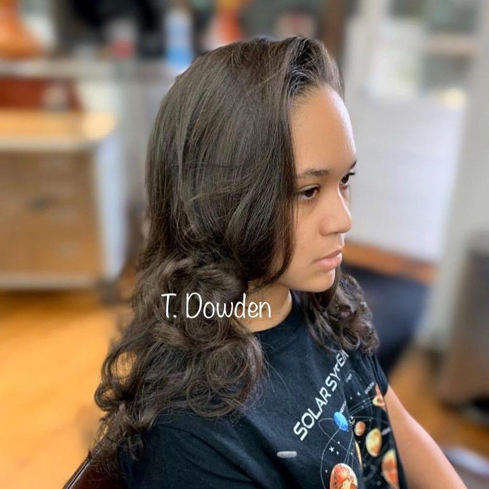 Long dark brown hair styled in soft waves after a blowout