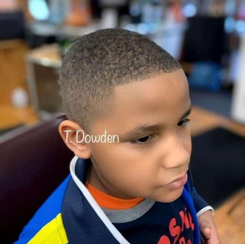 Young boy getting a low fade haircut in a Brooklyn salon chair