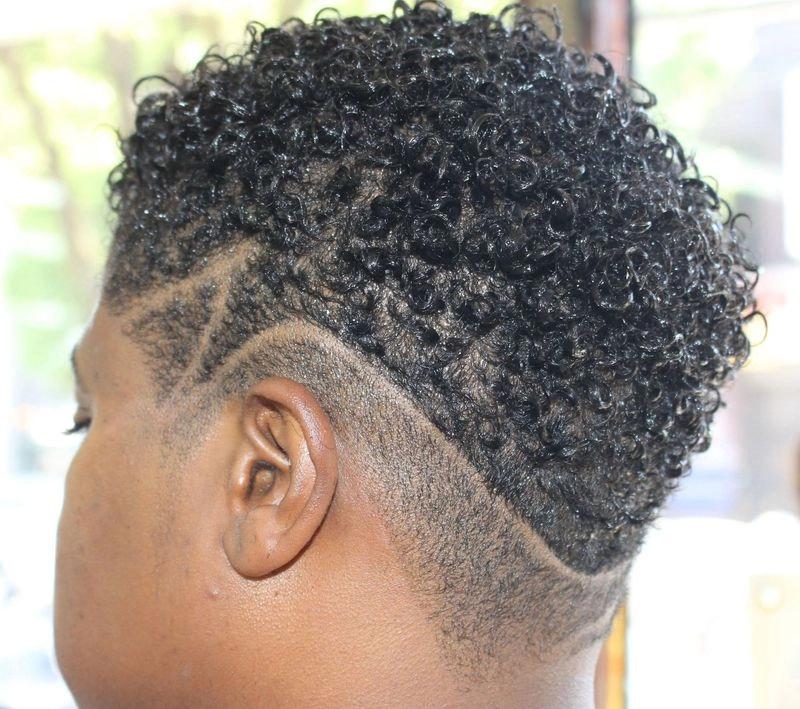 Tapered curly fade haircut with clean design lines