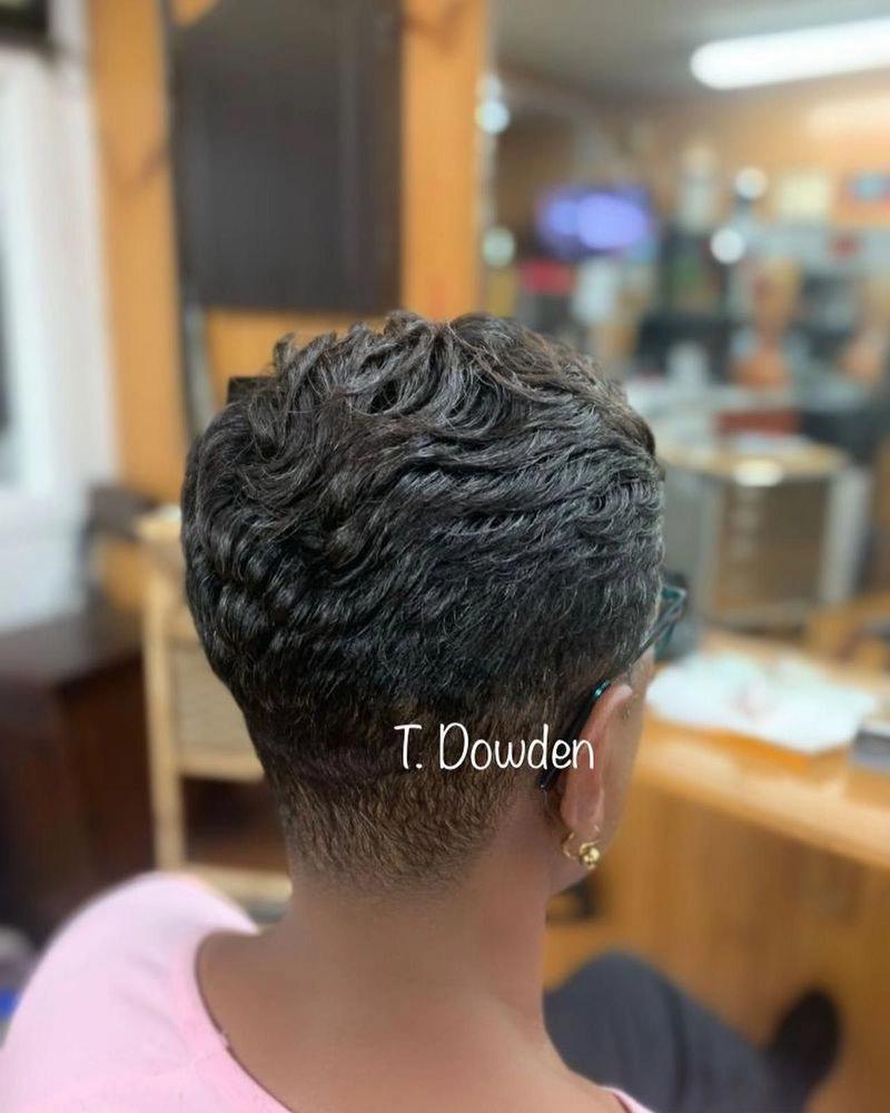 Short black pixie cut with textured waves and a tapered nape