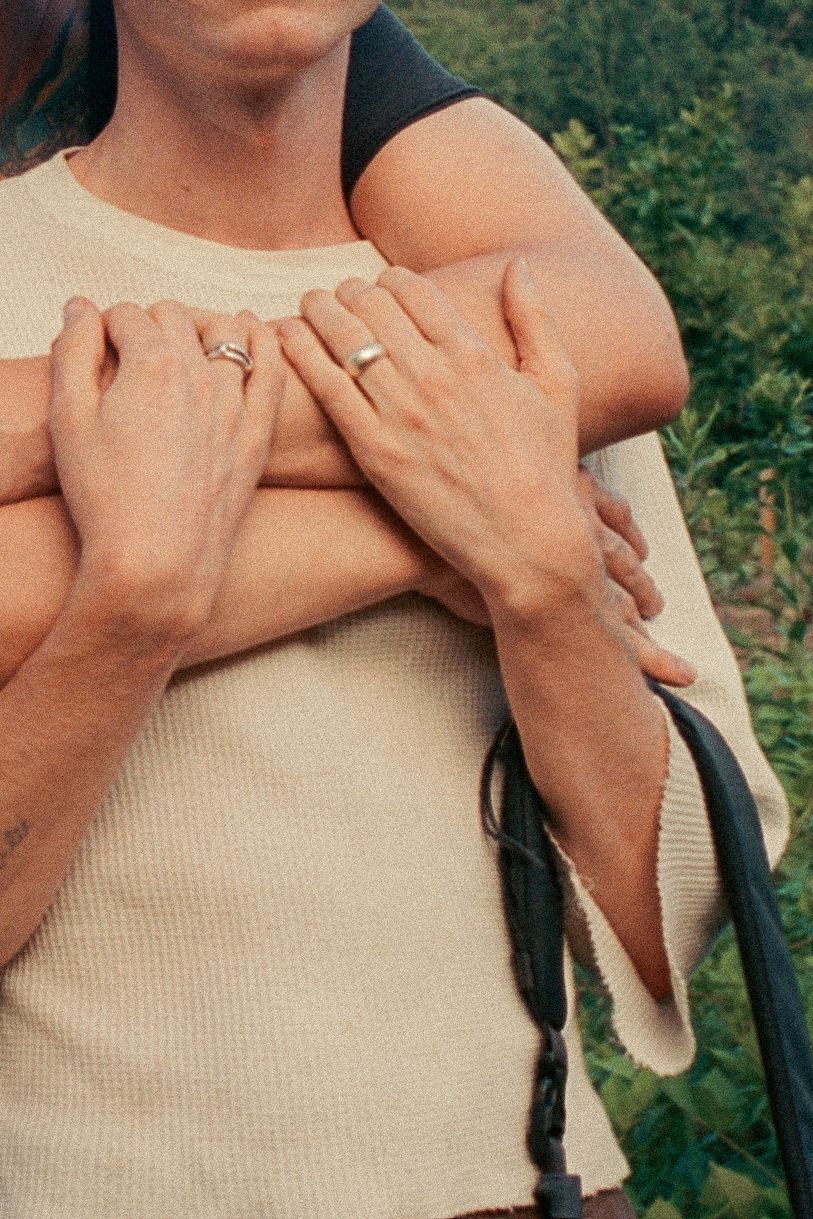 Two hands reaching up and meeting against a blue sky