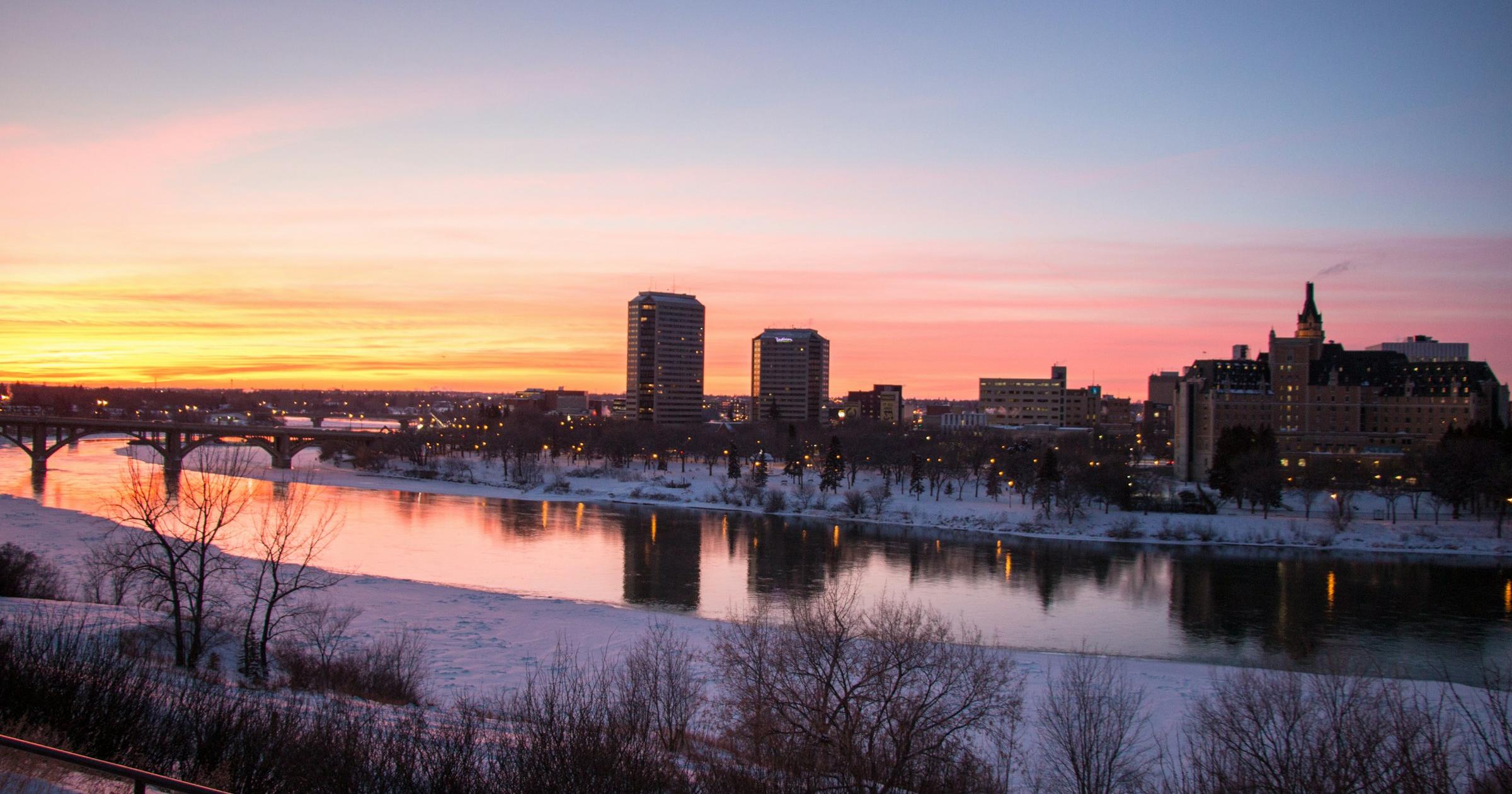 Saskatoon skyline and the South Saskatchewan River at sunset on a snowy winter evening