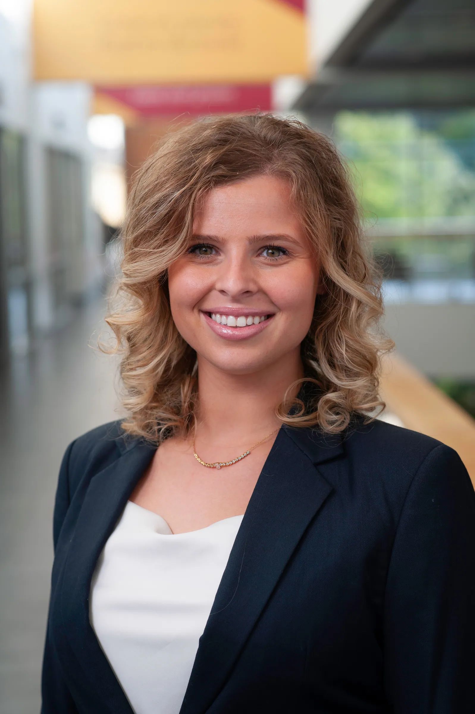 Portrait of Sierra, founder of Inspiring Florals, smiling in a navy blazer