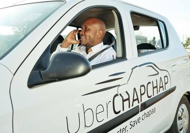 Uber driver on phone: The global firm is cutting more than 10,000 jobs in 70 countries 