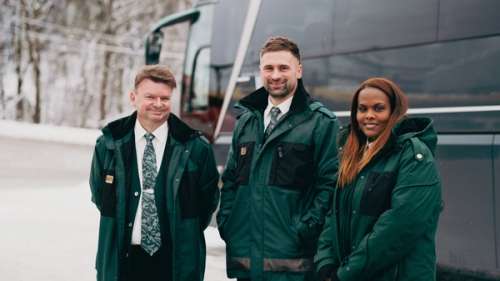 Tre Vy-kollegaer foran en buss