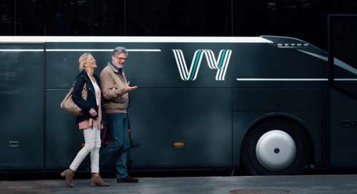 Mann og dame foran en Vy buss