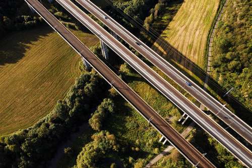 Dronefoto av vei og togskinner i landlige omgivelser