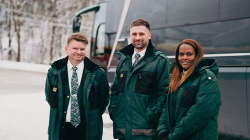 Tre Vy-kollegaer foran en buss