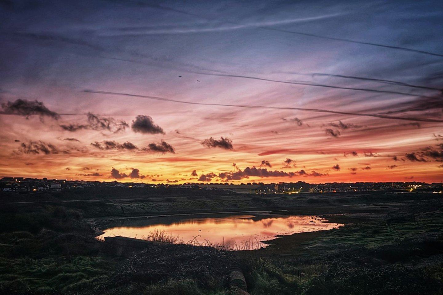 Sunset reflecting over a lake with scattered clouds