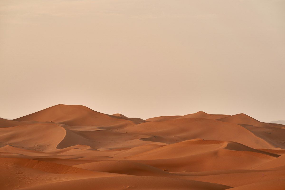 Rolling sand dunes under a hazy sky