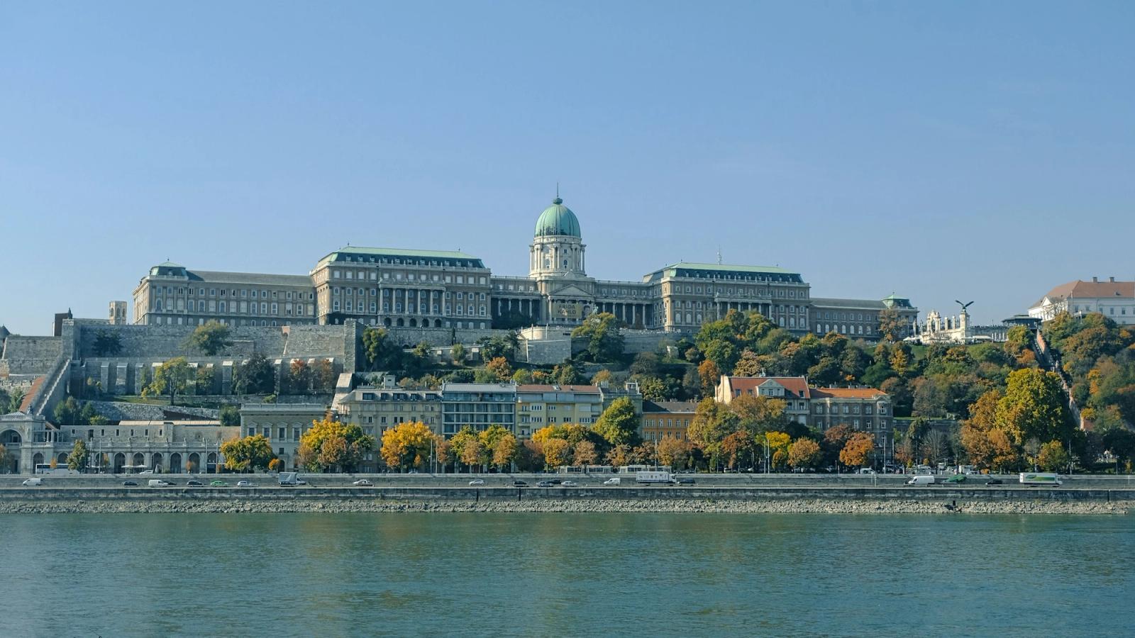 A budai Várpalota a Duna felett tiszta időben, alatta a rakparti budapesti bérházakkal
