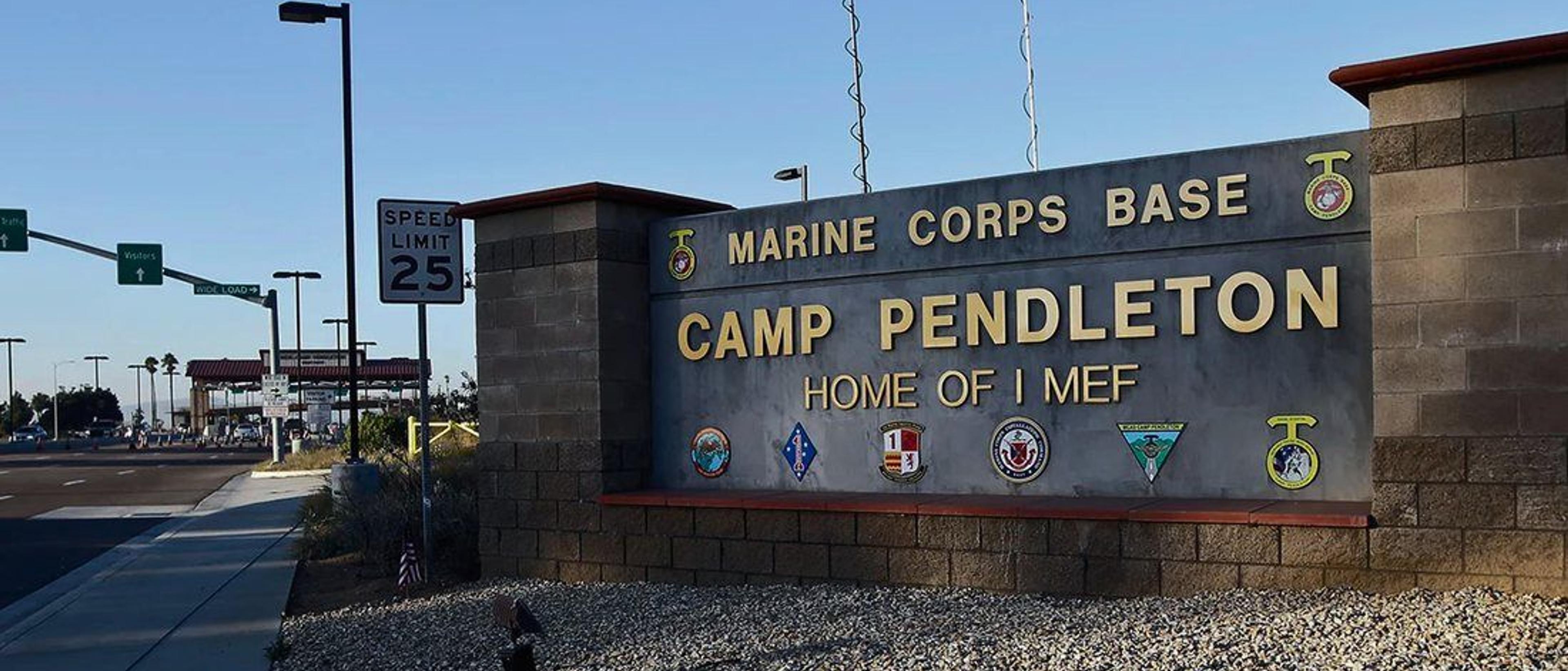 The entrance sign at Marine Corps Base Camp Pendleton beneath a clear blue sky