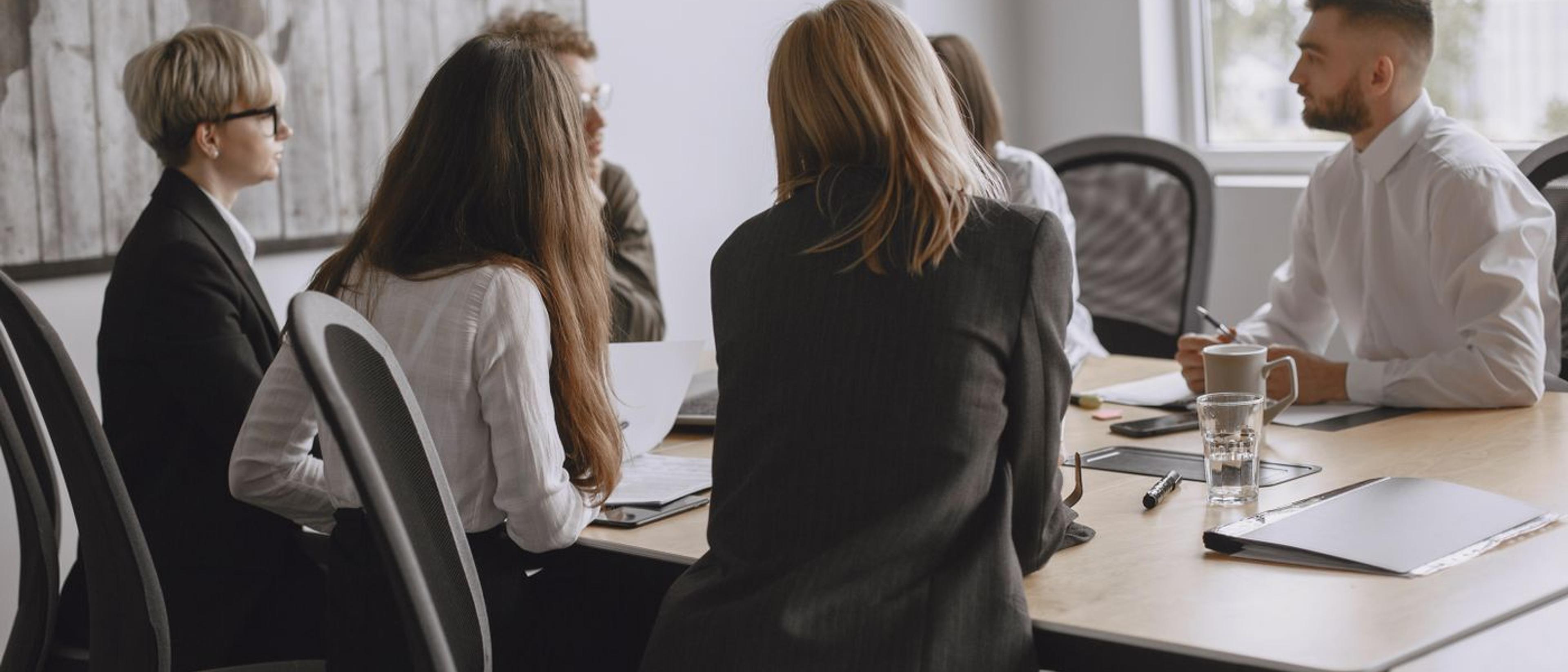 Colleagues discussing plans around a meeting table