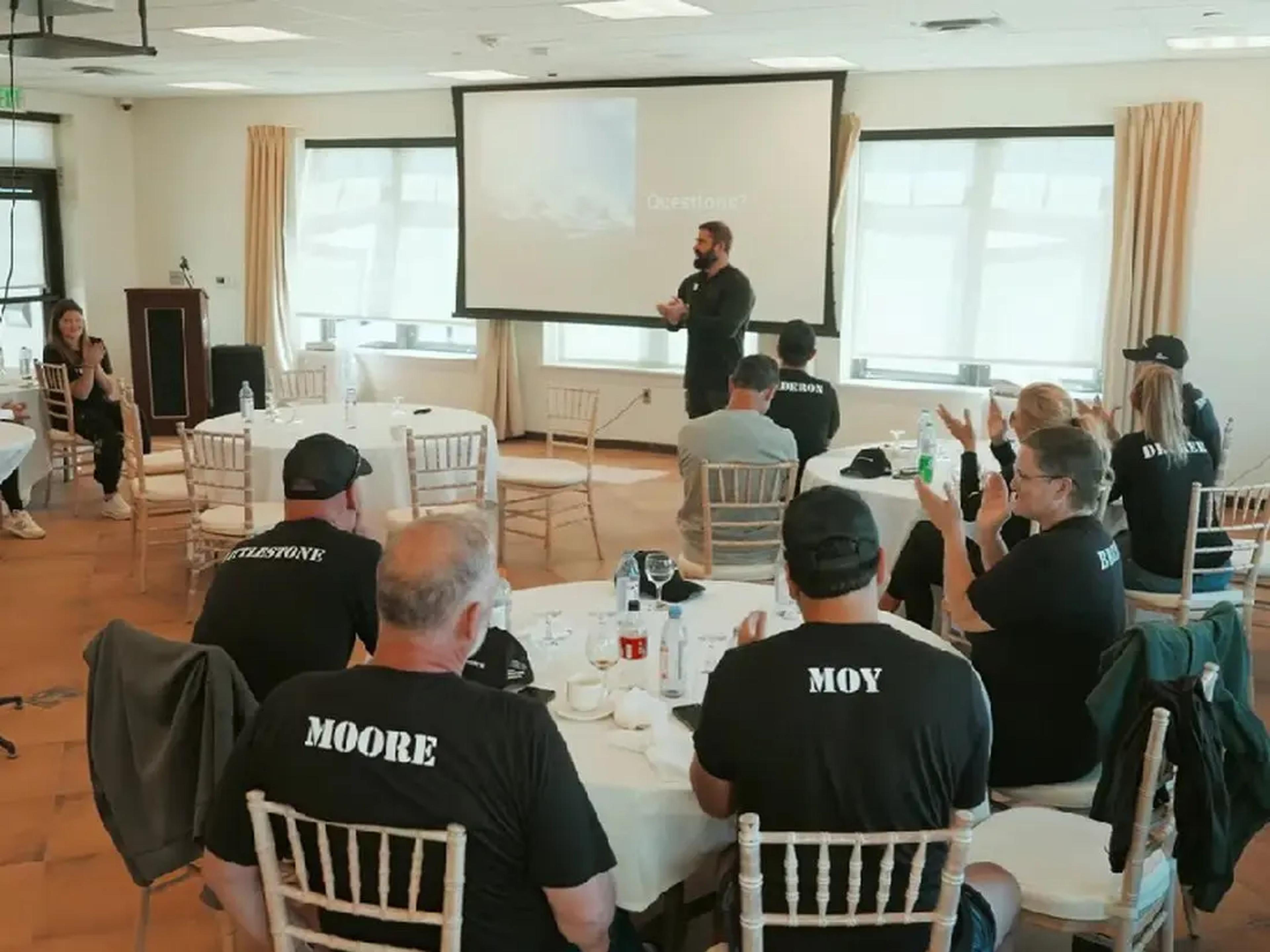 A corporate group listens to a facilitated keynote during an Experience Camp Pendleton programme