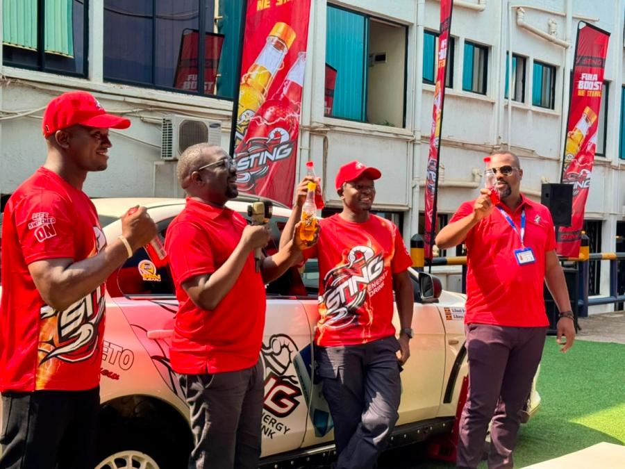 Rogers Angunzu - Commercial Manager CBL (holding the microphone), together with the driver and other staff address the crowd during the sponsorship announcement in Kampala.