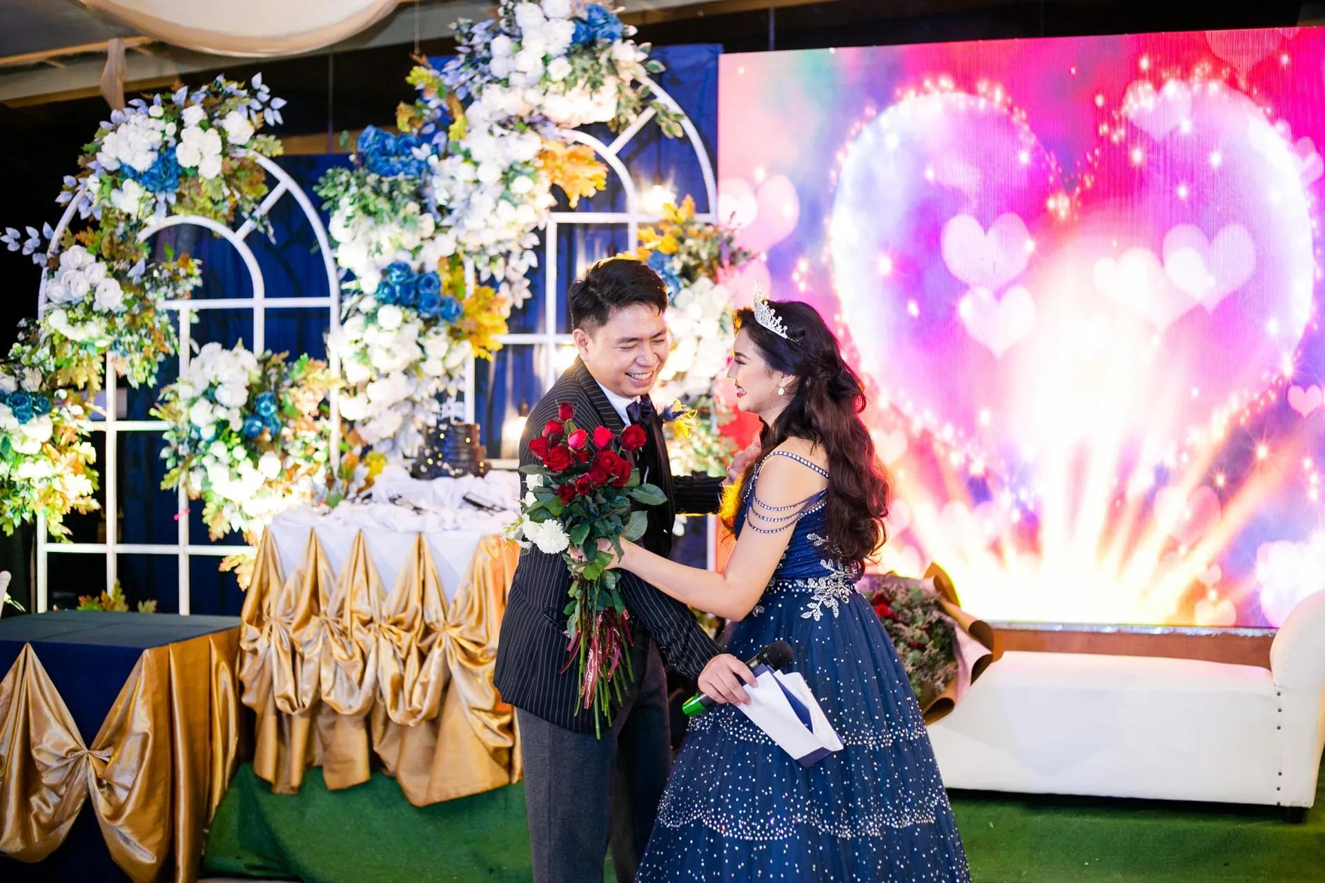 A debut emcee presenting the 18 roses to the debutante on stage