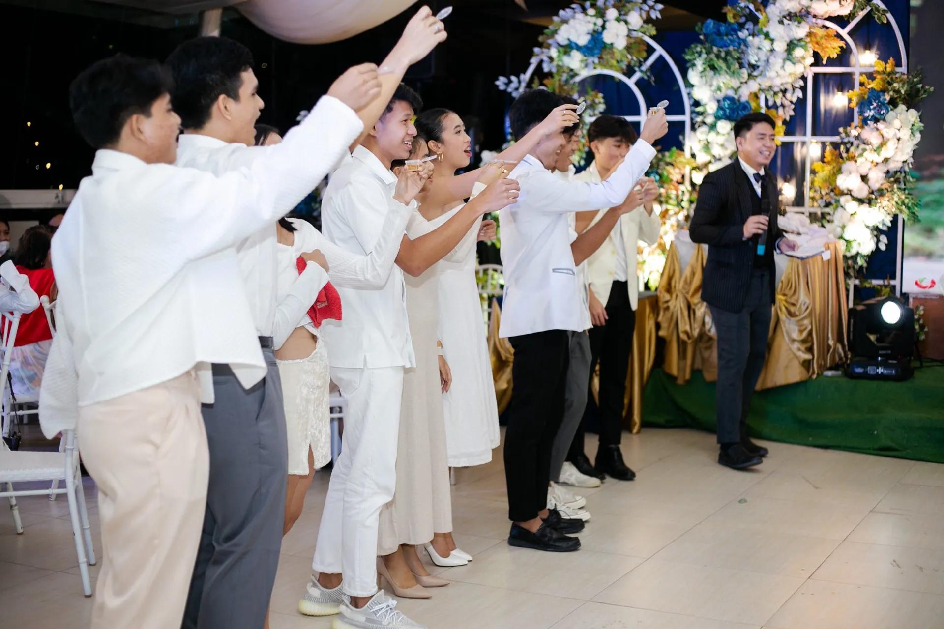 Guests raising a toast while a bilingual emcee hosts a reception in the Philippines