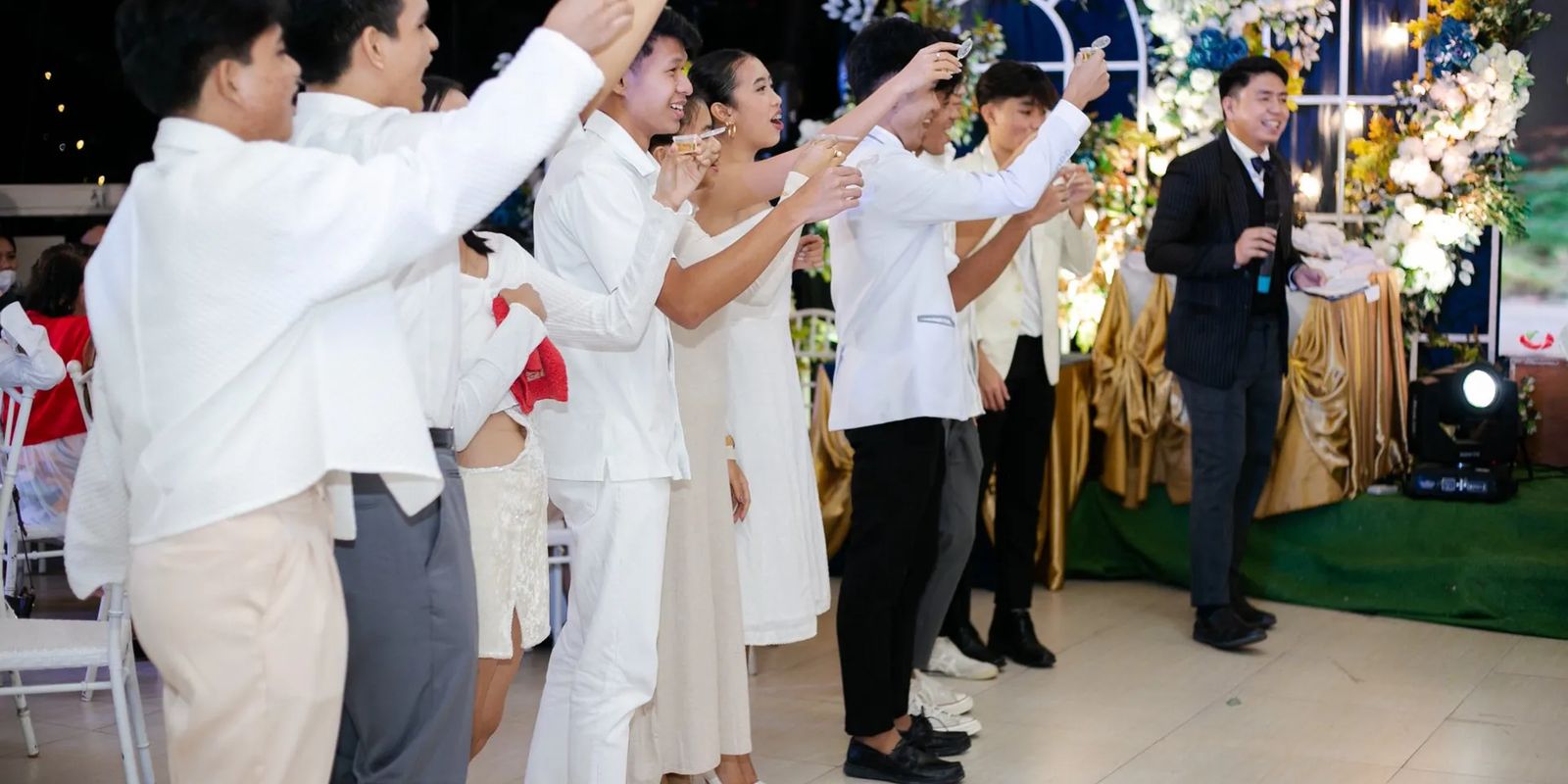 Guests raising a toast while a bilingual emcee hosts a reception in the Philippines