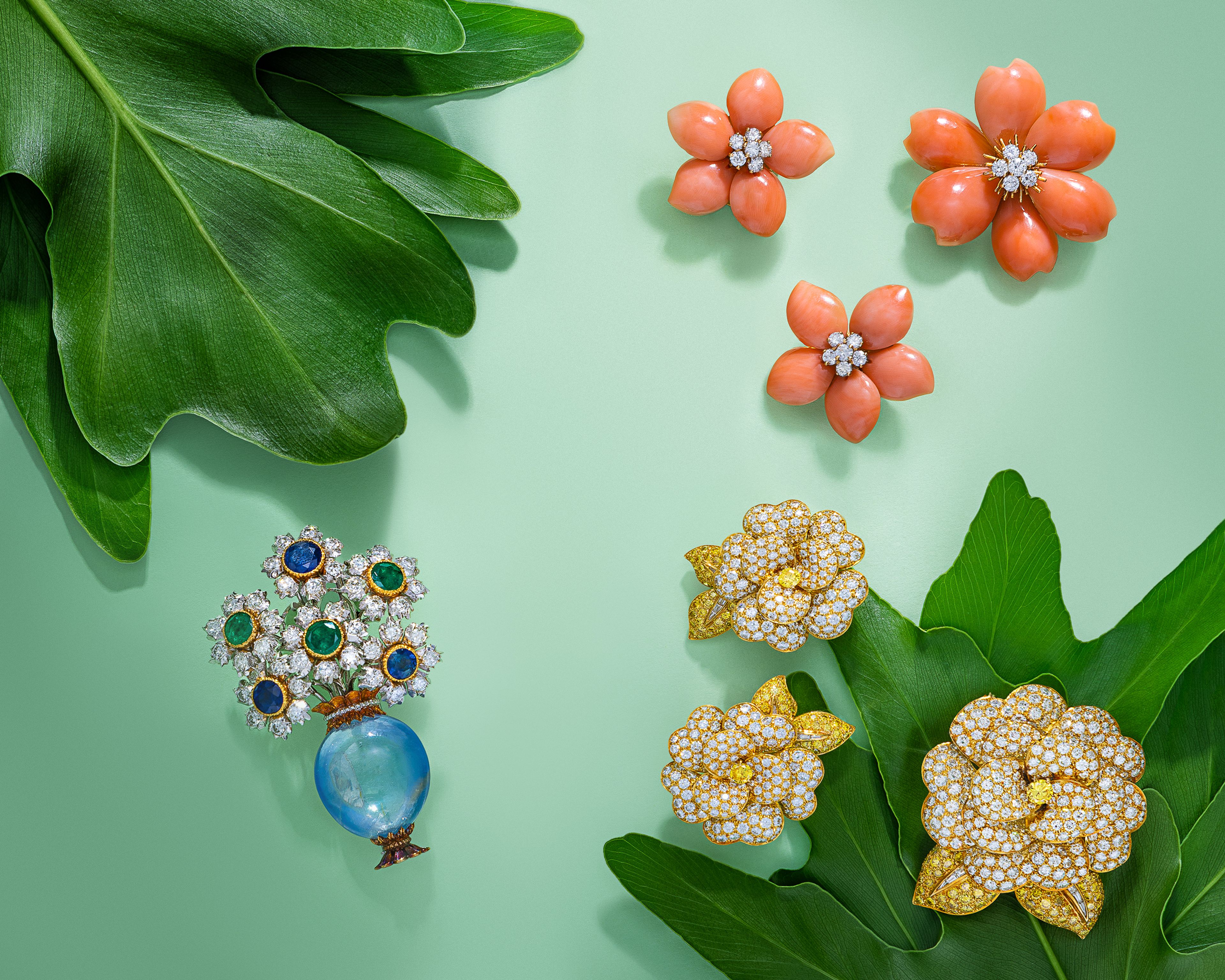 From left to right: Lot 23 | Buccellati, Sapphire, Emerald, and Diamond Giardinetto Brooch | Estimate: $12,000 - $18,000; 
Lot 87 | Van Cleef & Arpels, 'Rose de Noël', Coral and Diamond Brooch and Earrings | Estimate: $45,000 - $55,000; 
Lot 73 | Van Cleef & Arpels, Diamond, Yellow Diamond, and Yellow Gold 'Gardenia' Earrings | Estimate: $40,000 - $60,000