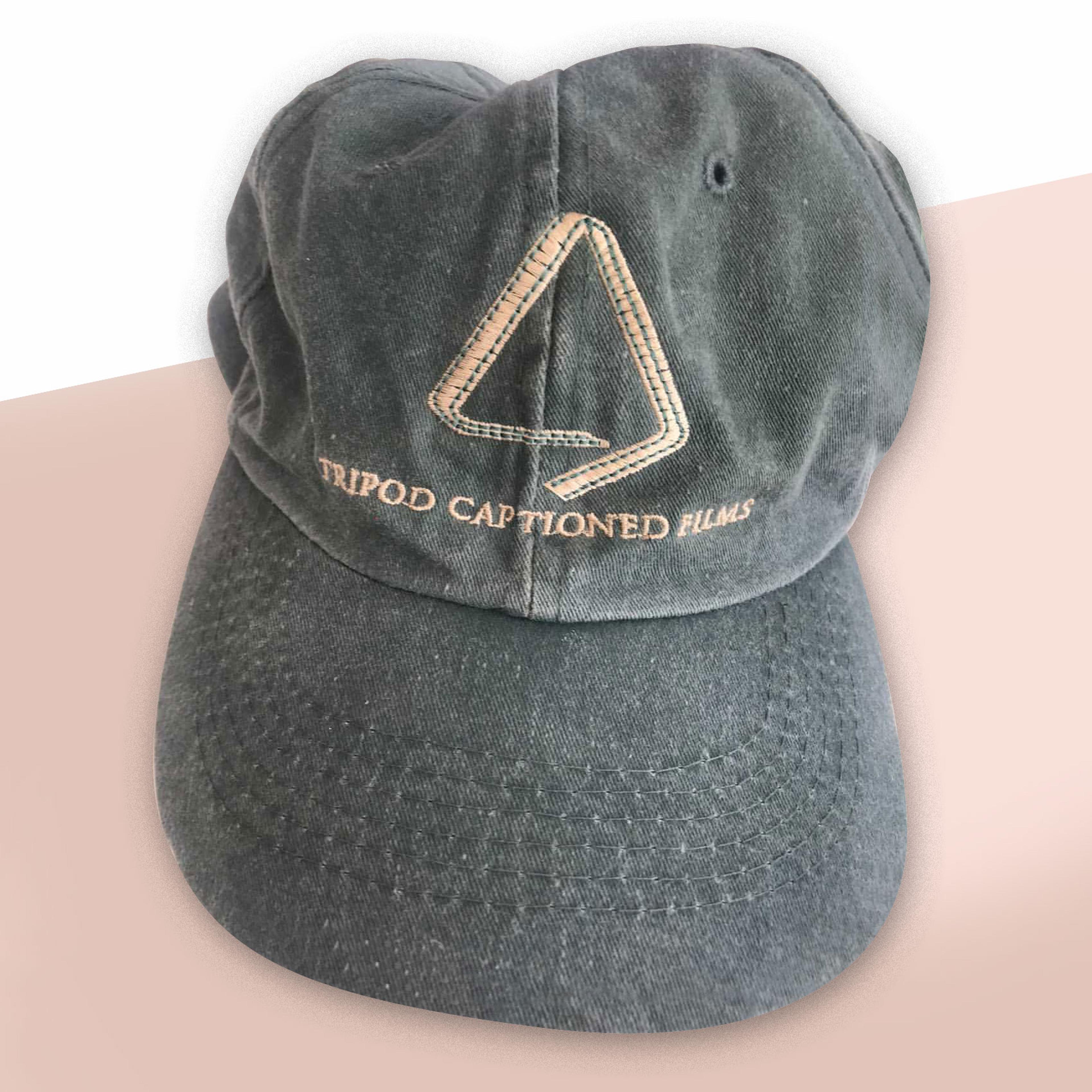 A grey cap embroidered “Tripod Captioned Films”