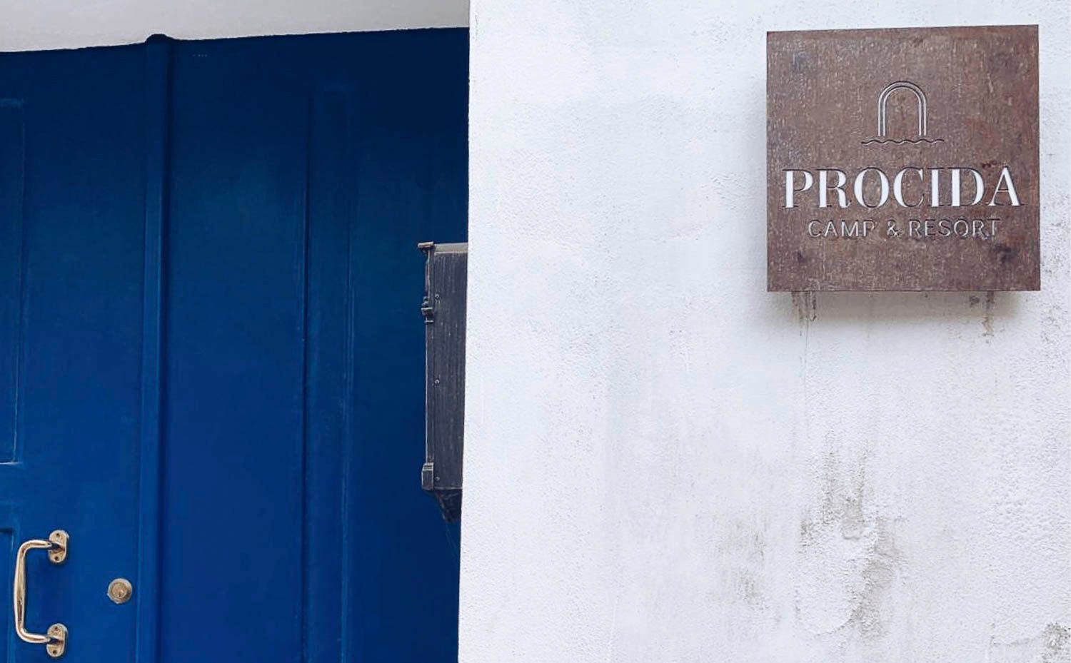 foto a colori di un portone e una barca in mare
