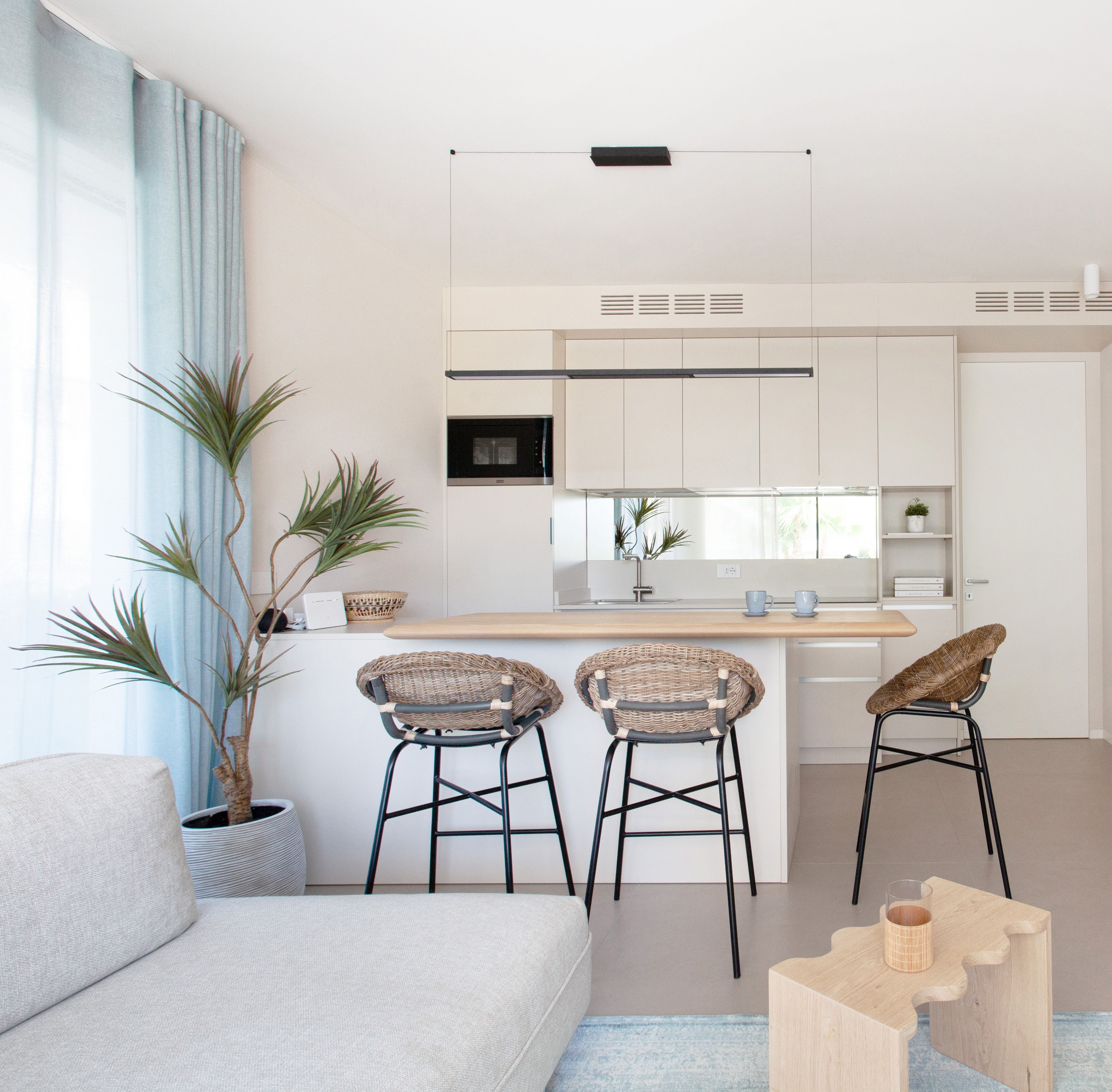 Foto a colori con cucina bianca, con isola e sgabelli 