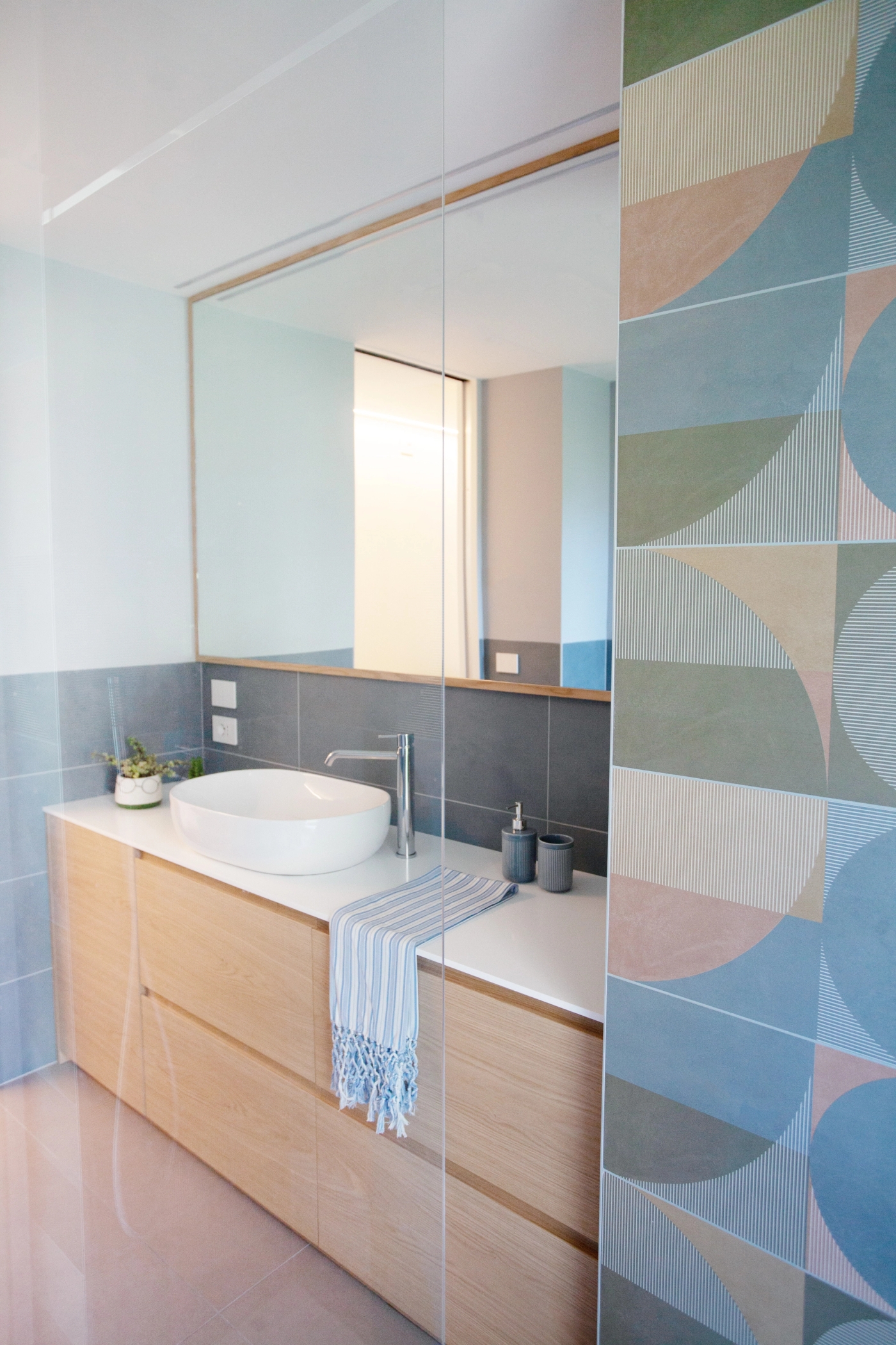 foto a colori con bagno in legno di rovere e rivestimenti azzurri, verdi e beige