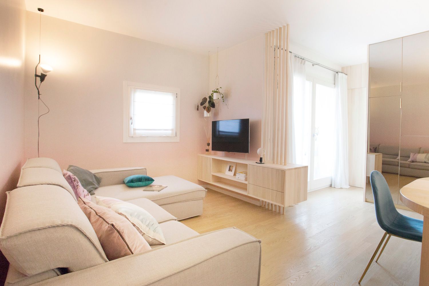 foto a colori di una zona giorno con parete specchiata