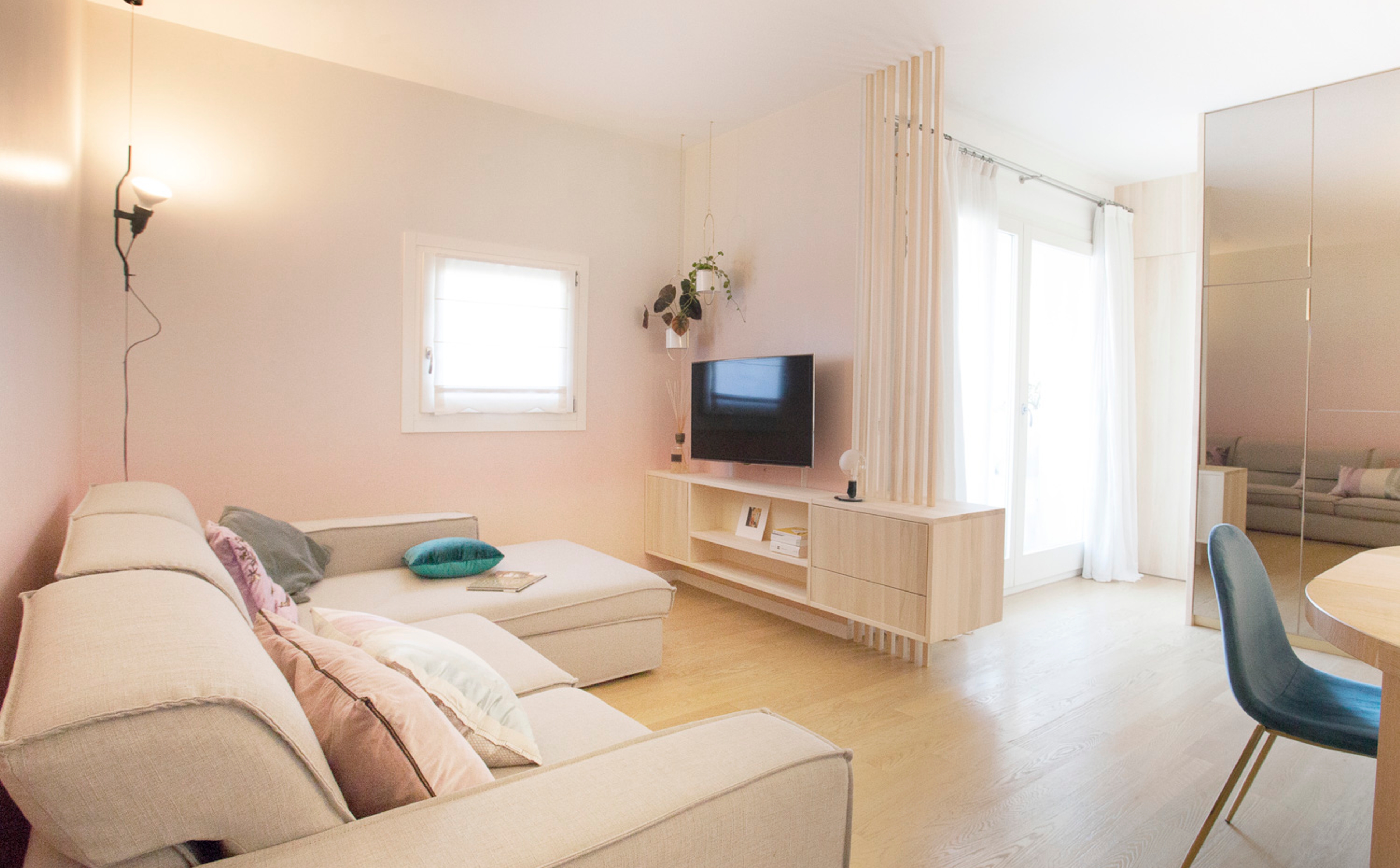 foto a colori di una zona giorno con parete specchiata