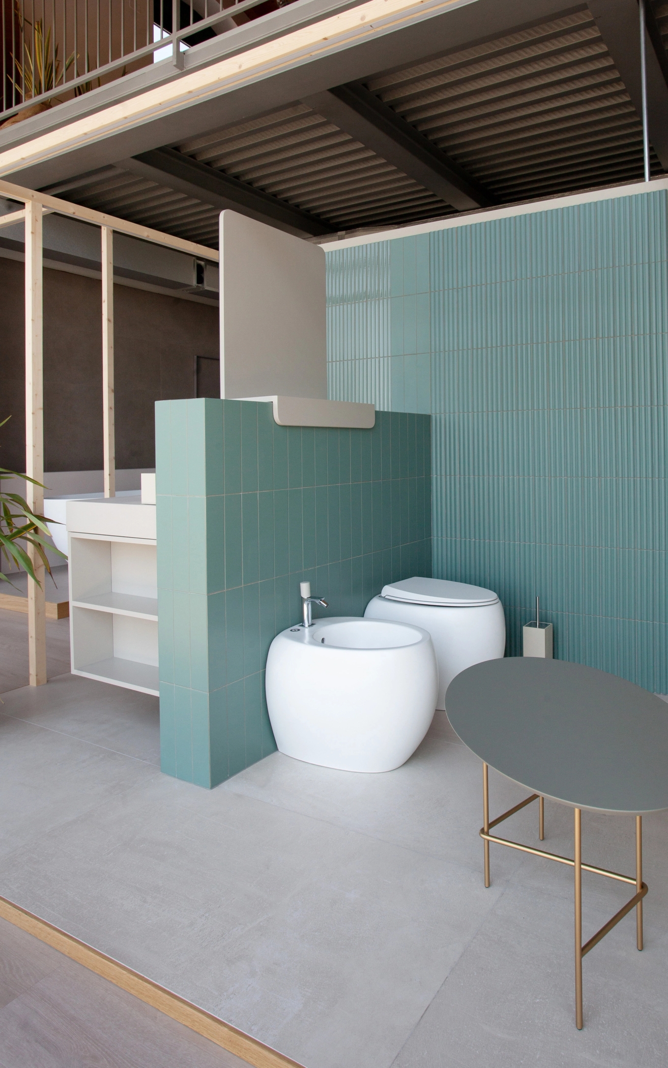 foto a colori, dettaglio showroom bagno con piastrelle verde salvia e sanitari bianchi